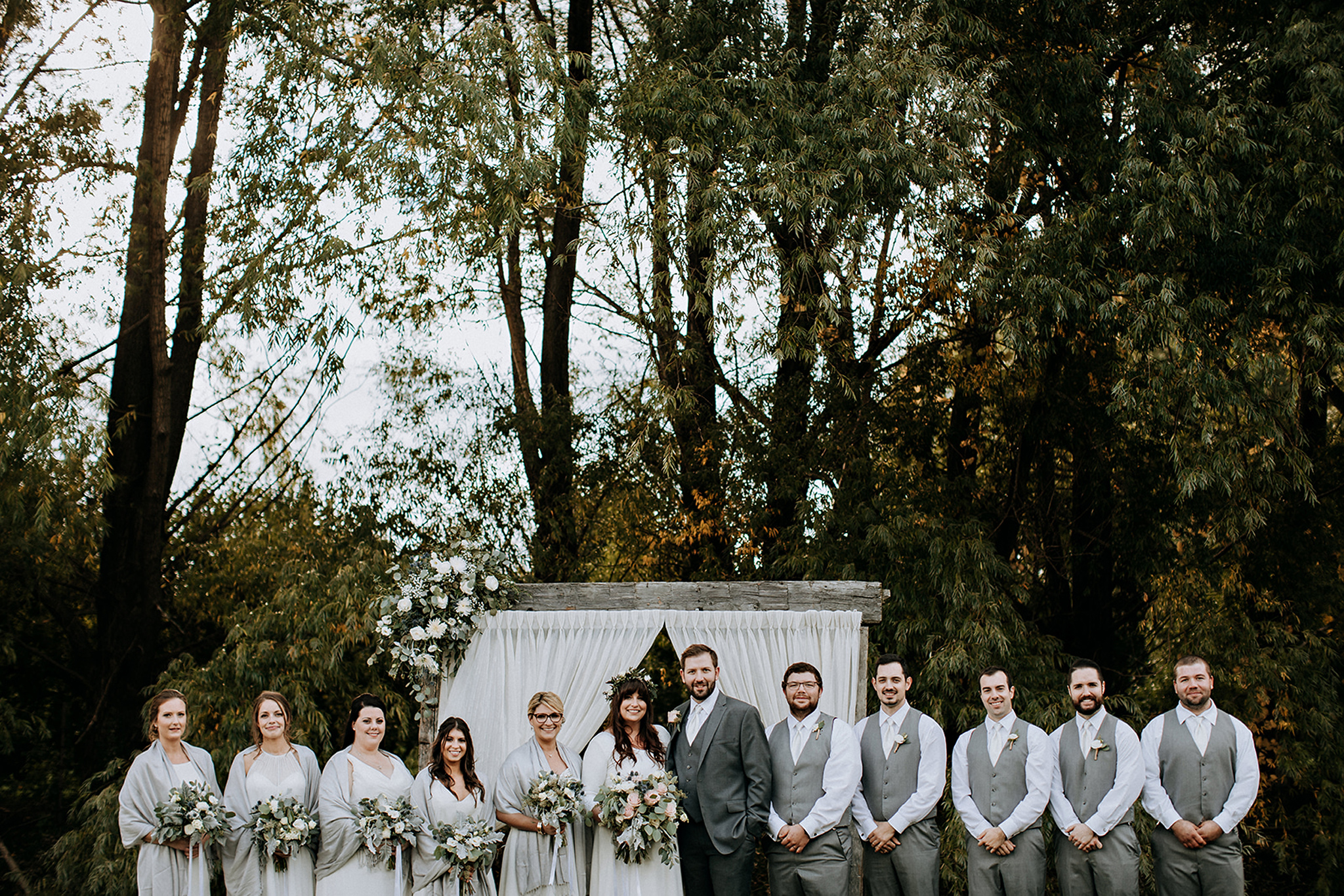 wedding party with barn beam ceremony arch in meaford