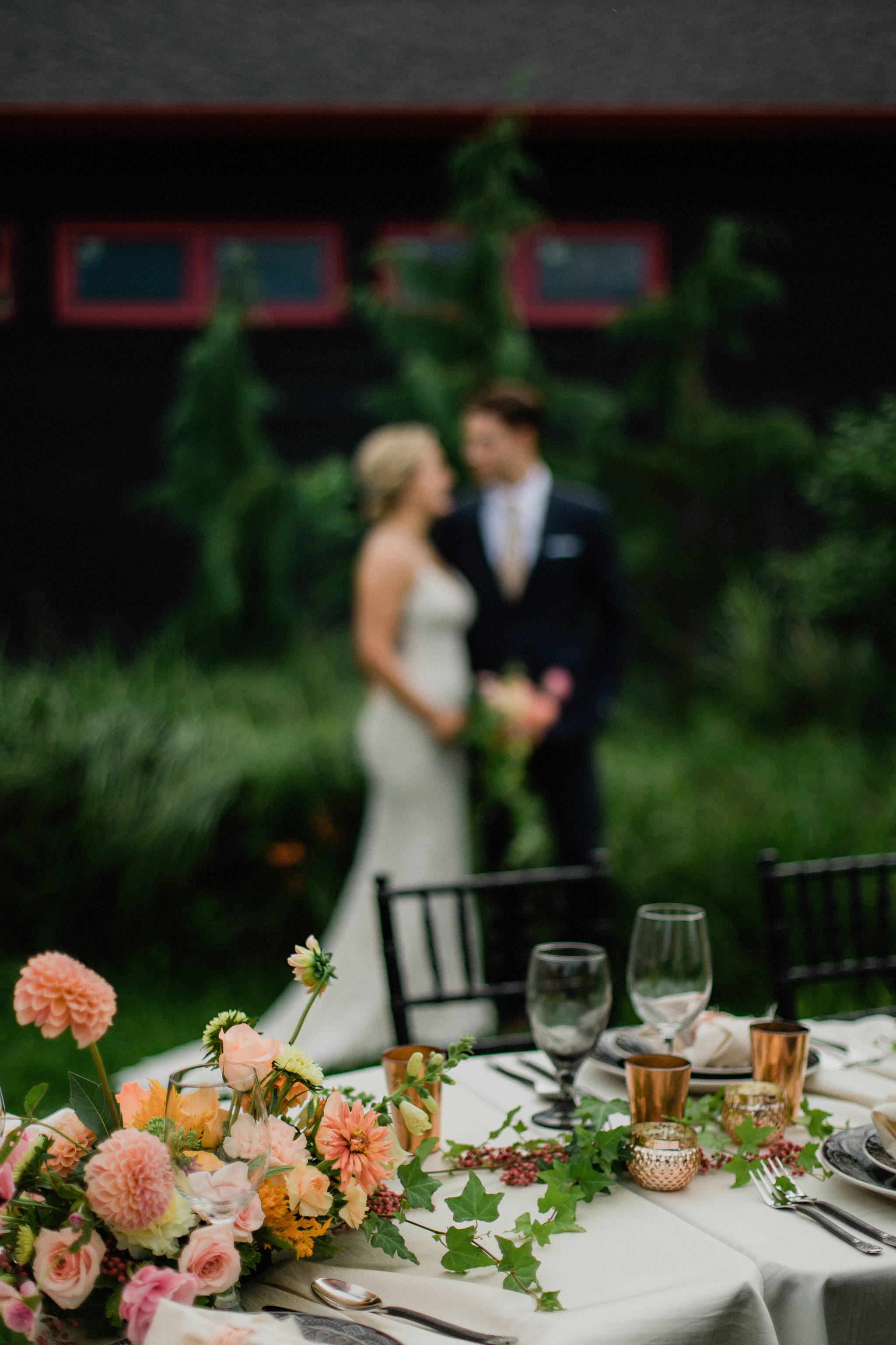 Bride and groom with their coral, copper and smoke table setting