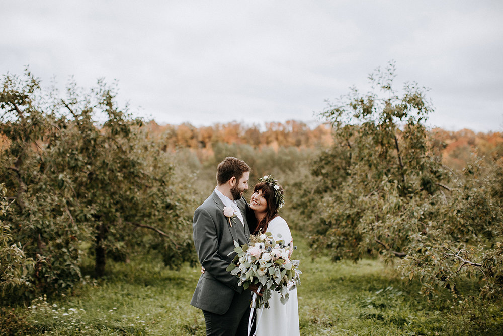 cozy couples portrait in apple orchard at meaford barn wedding