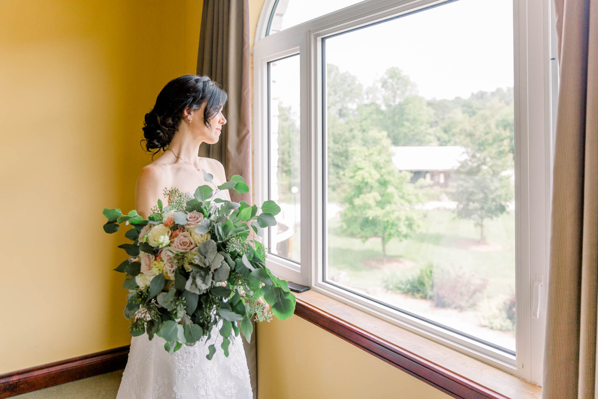 Bride standing in the window of the Bridal suite at Walters Fall