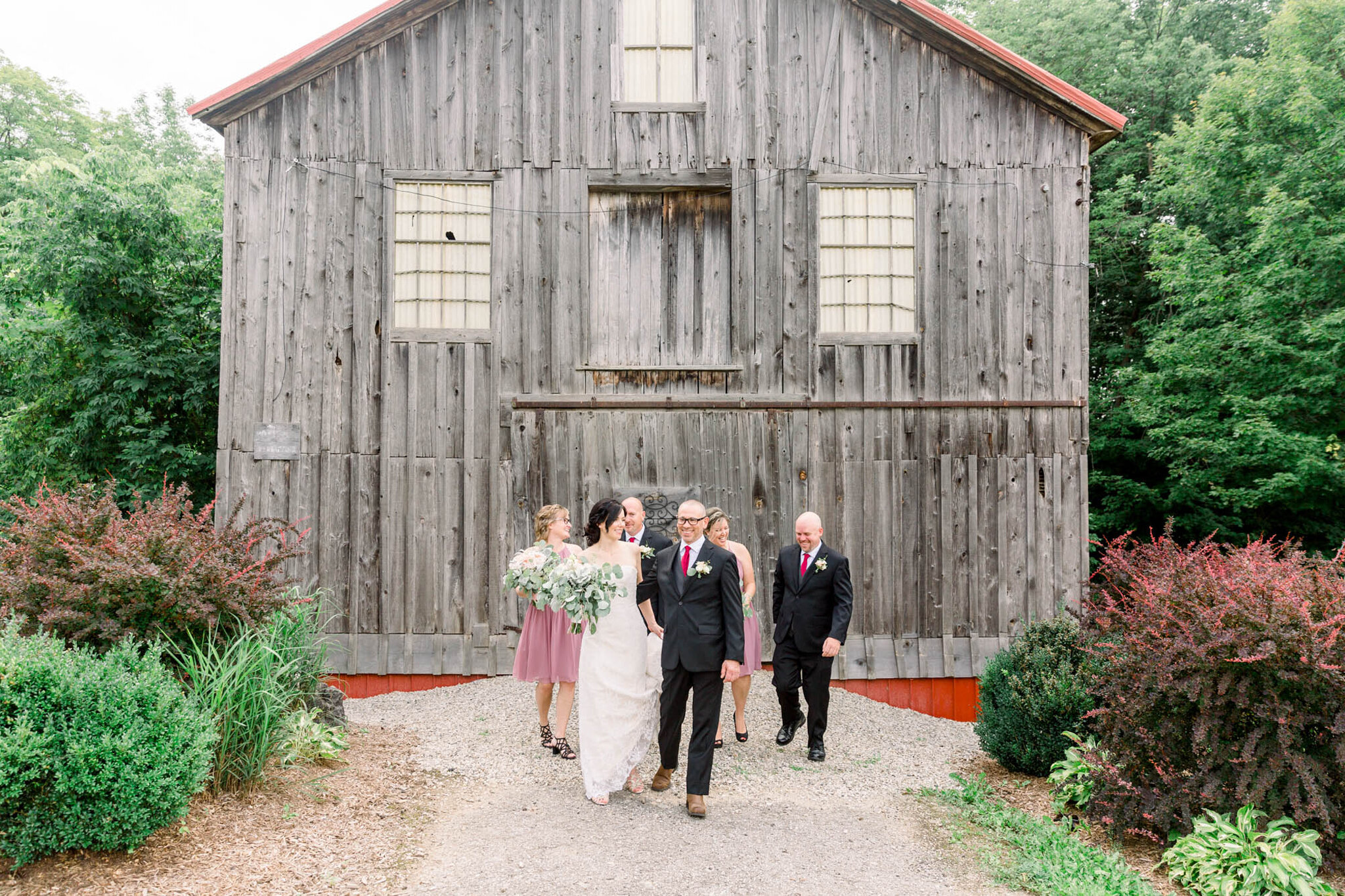 Wedding portraits in front of rustic barn at Walters Falls Inn a