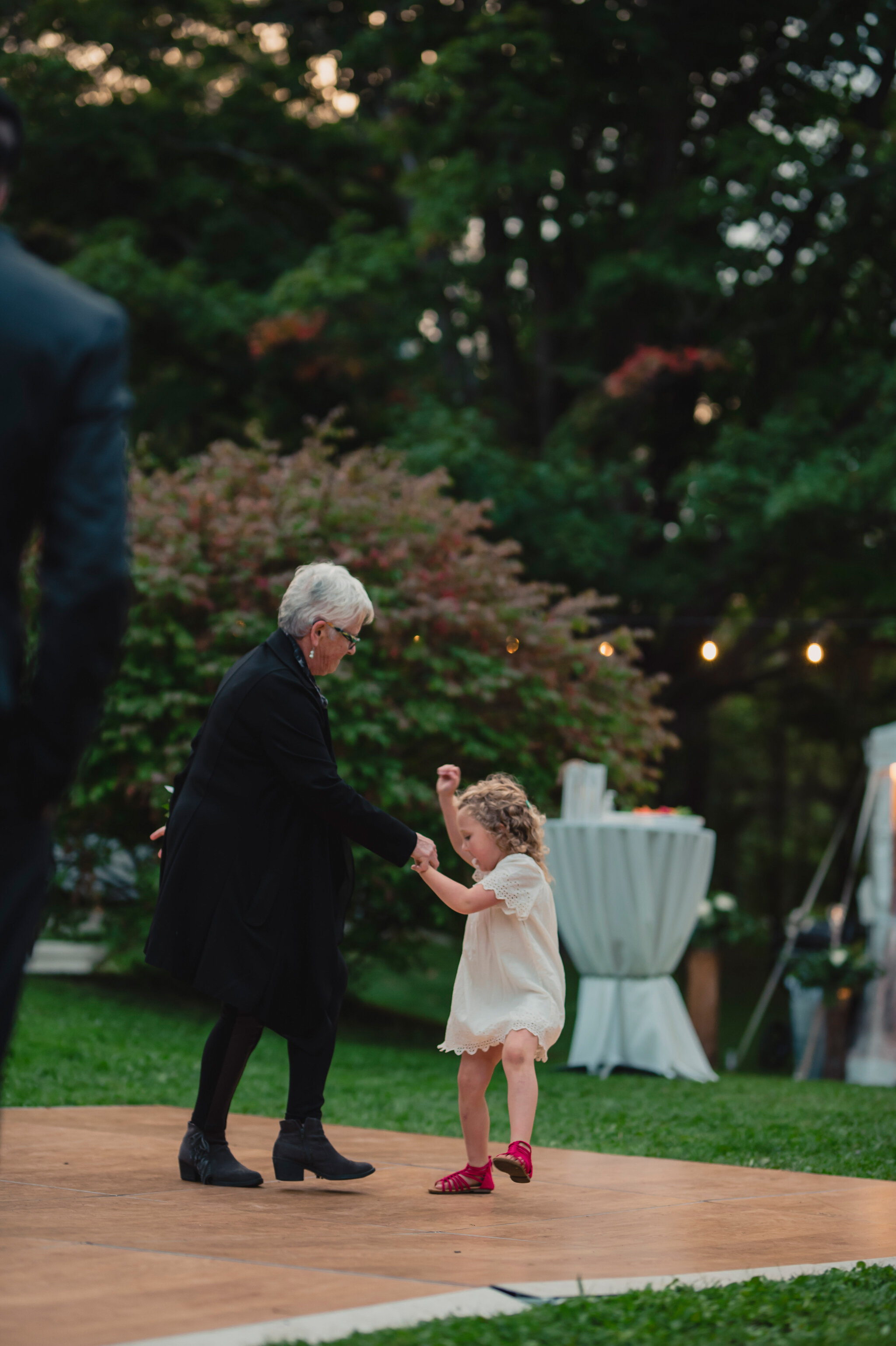 grandma and flower girl dance at backyard wedding