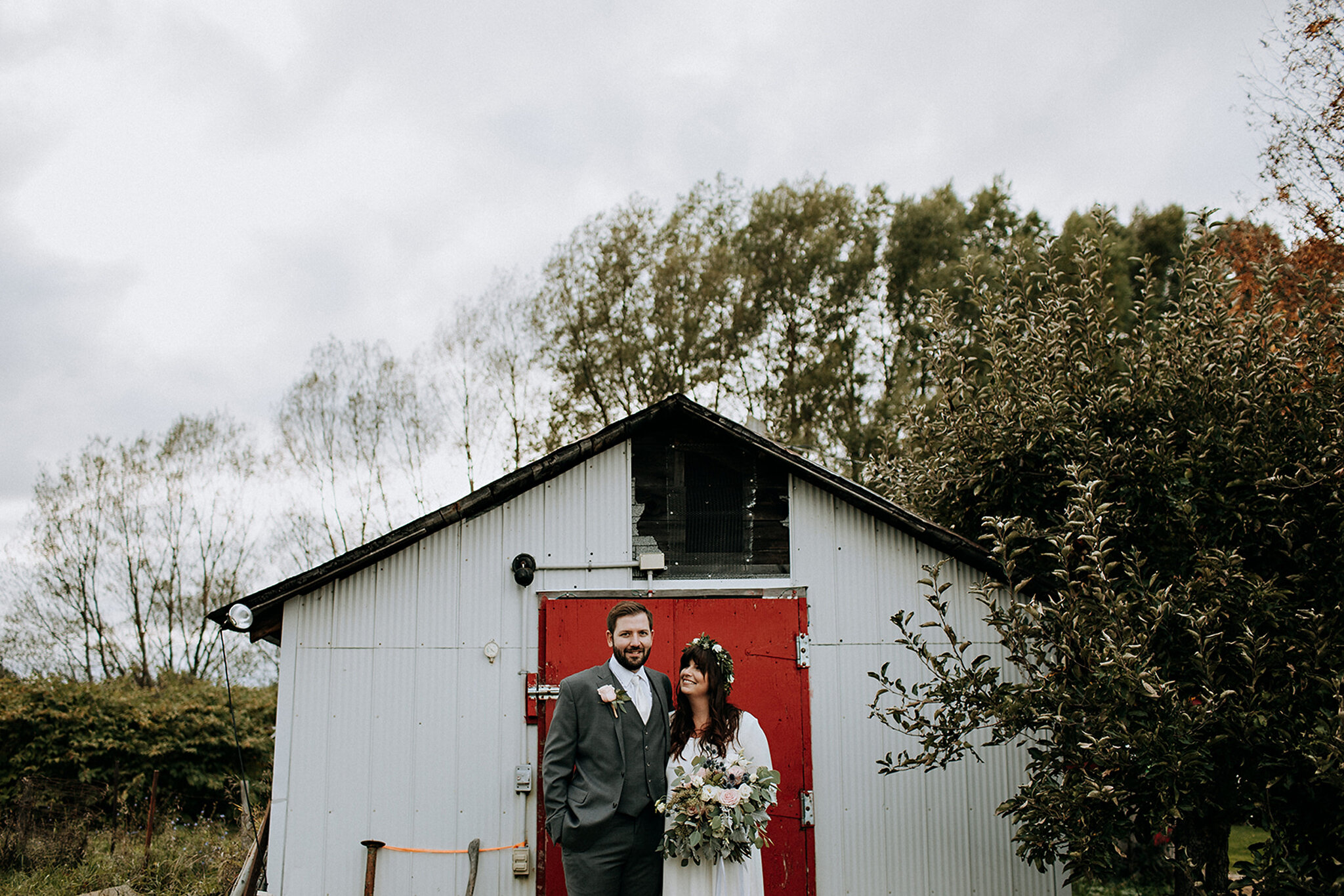 bride and groom with red door at meaford barn wedding