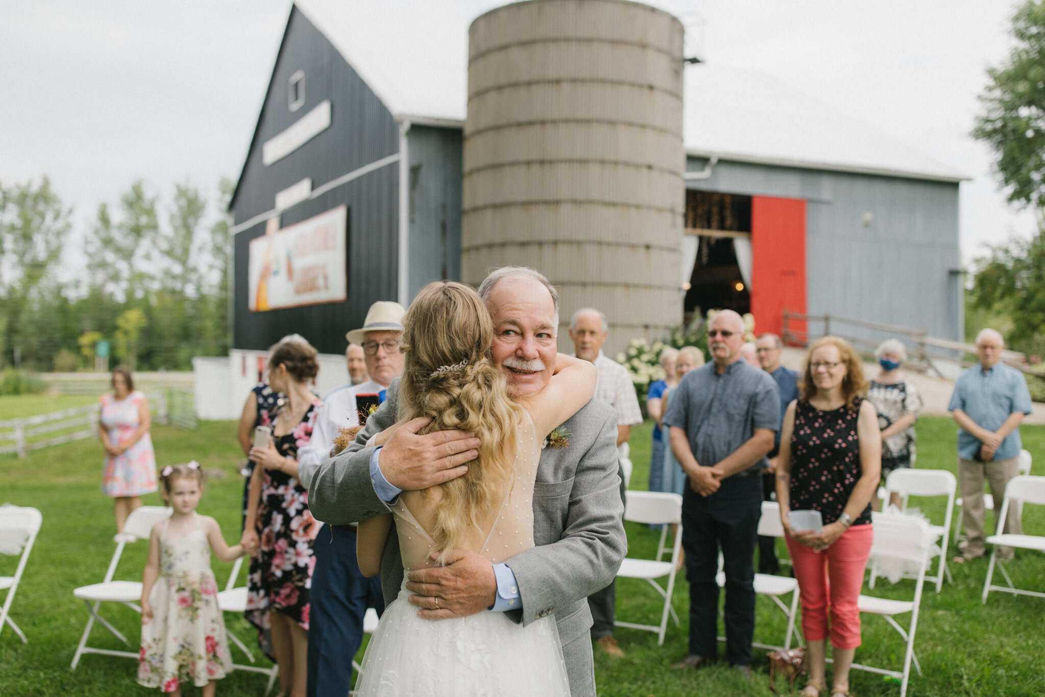 Bride hugs father outdoor wedding ceremony Meaford