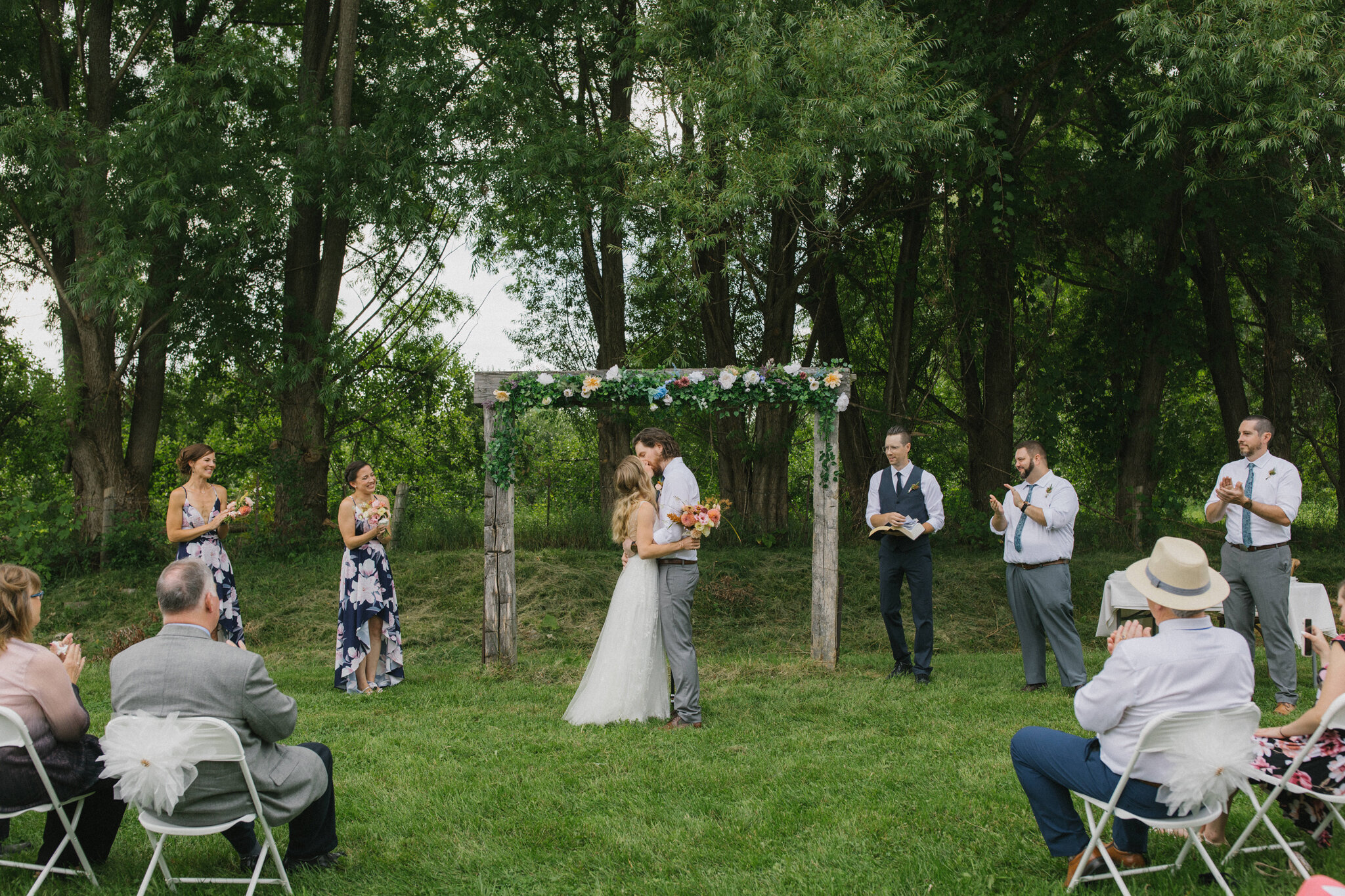 First kiss outdoor wedding ceremony wooden arch