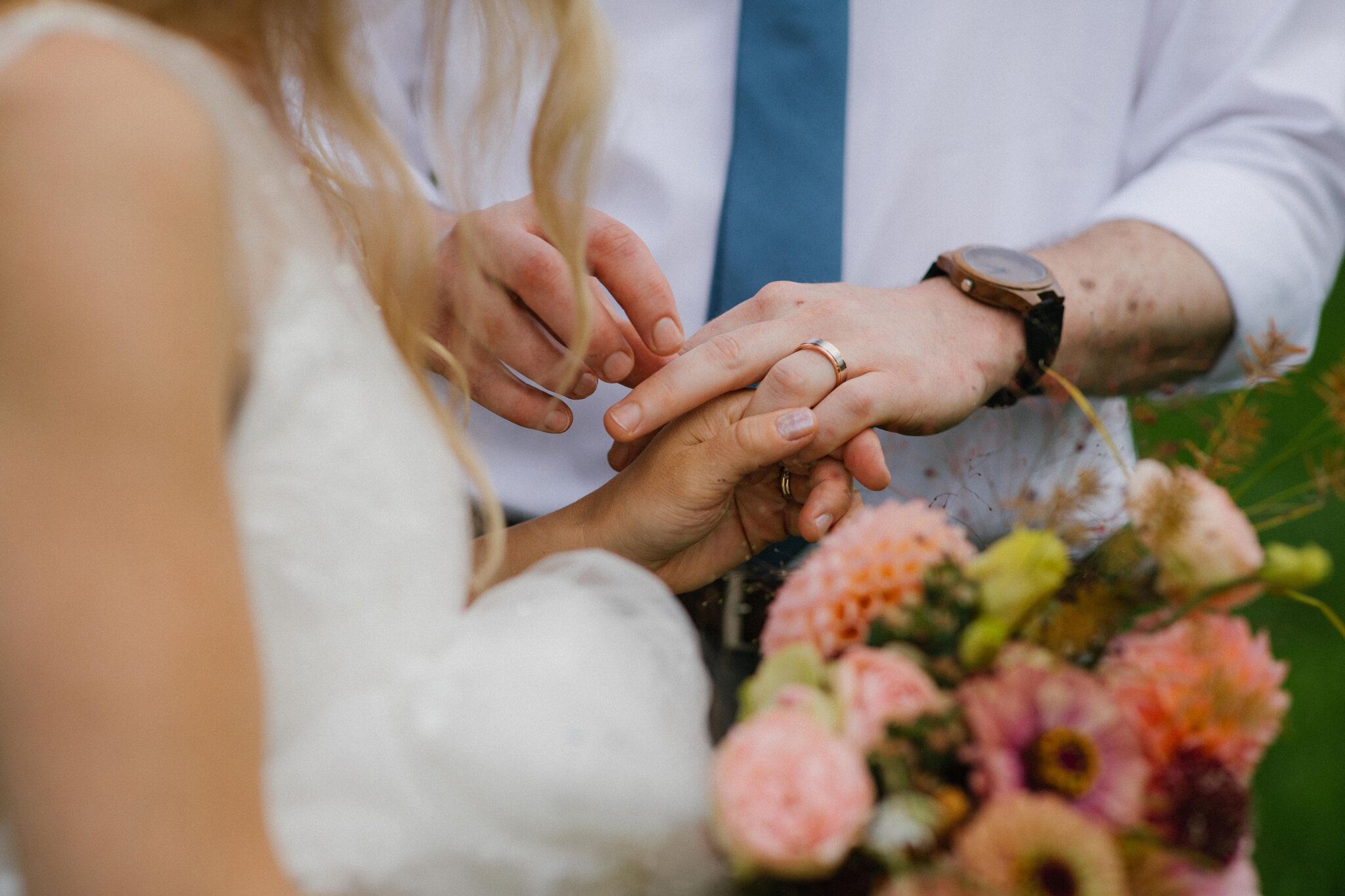 bride looks at wedding ring on groom