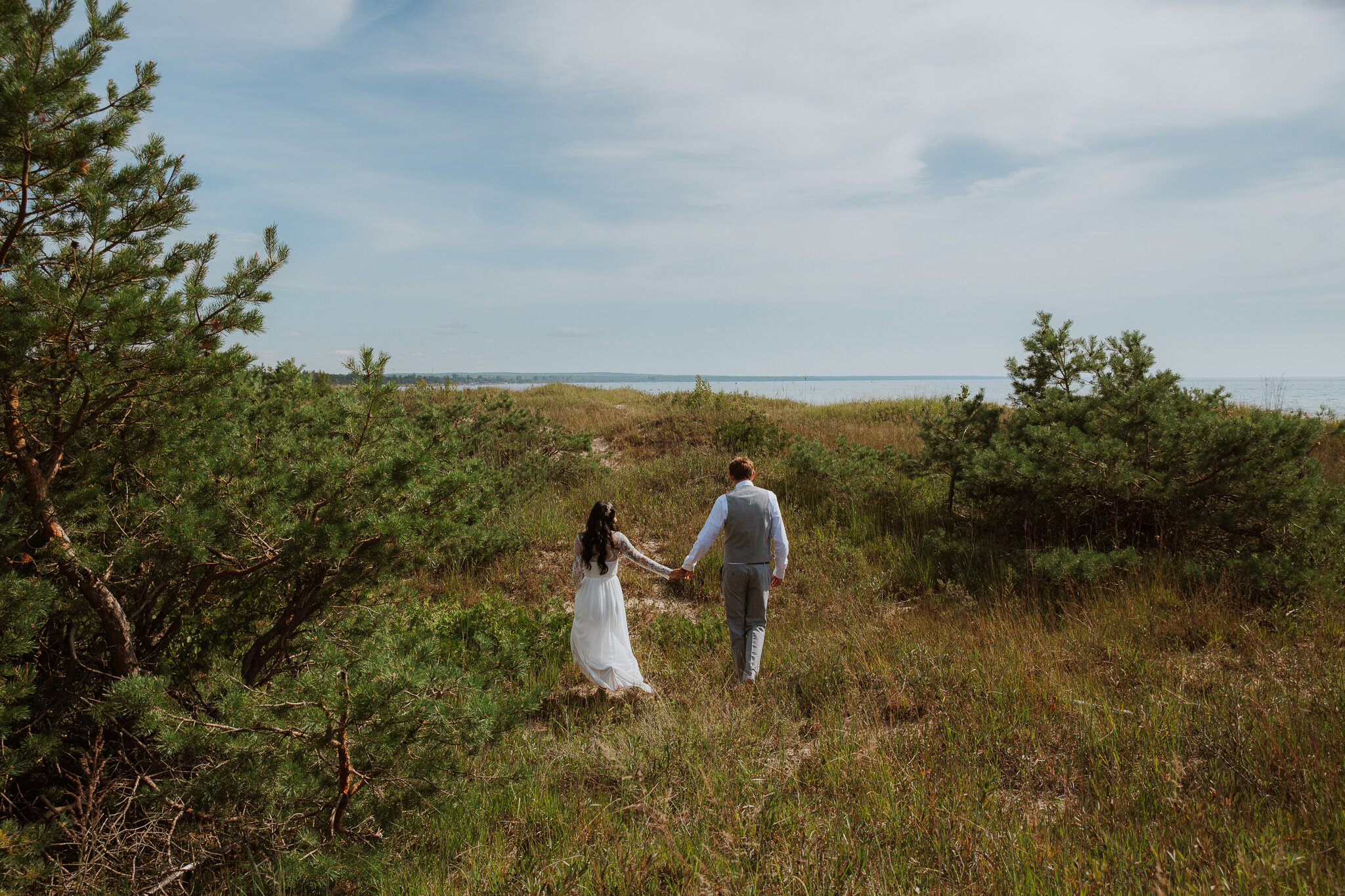 Bride and groom walk to sand dunes on georgian bay elopement