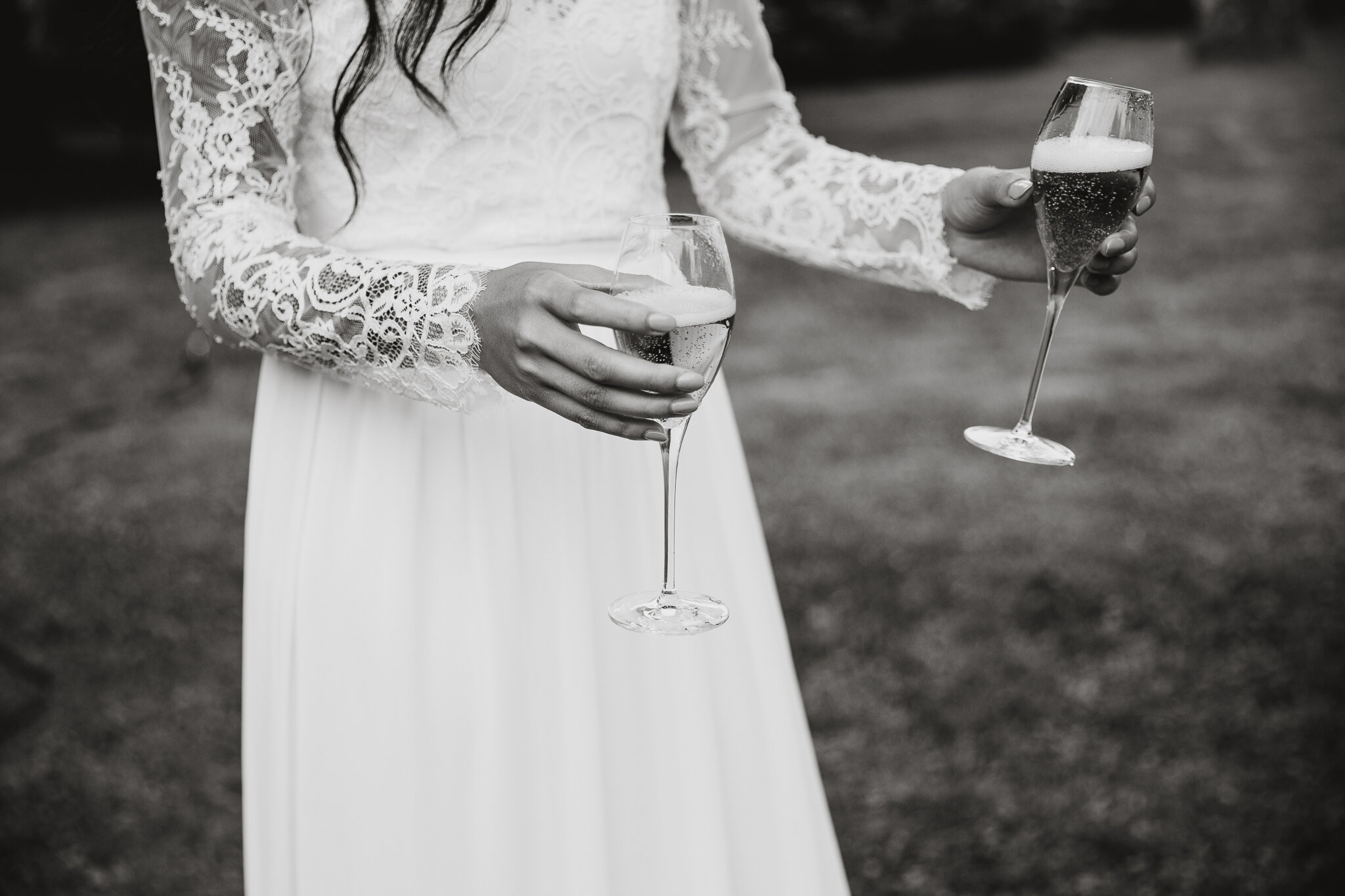 bride in lace wedding dress holding champagne