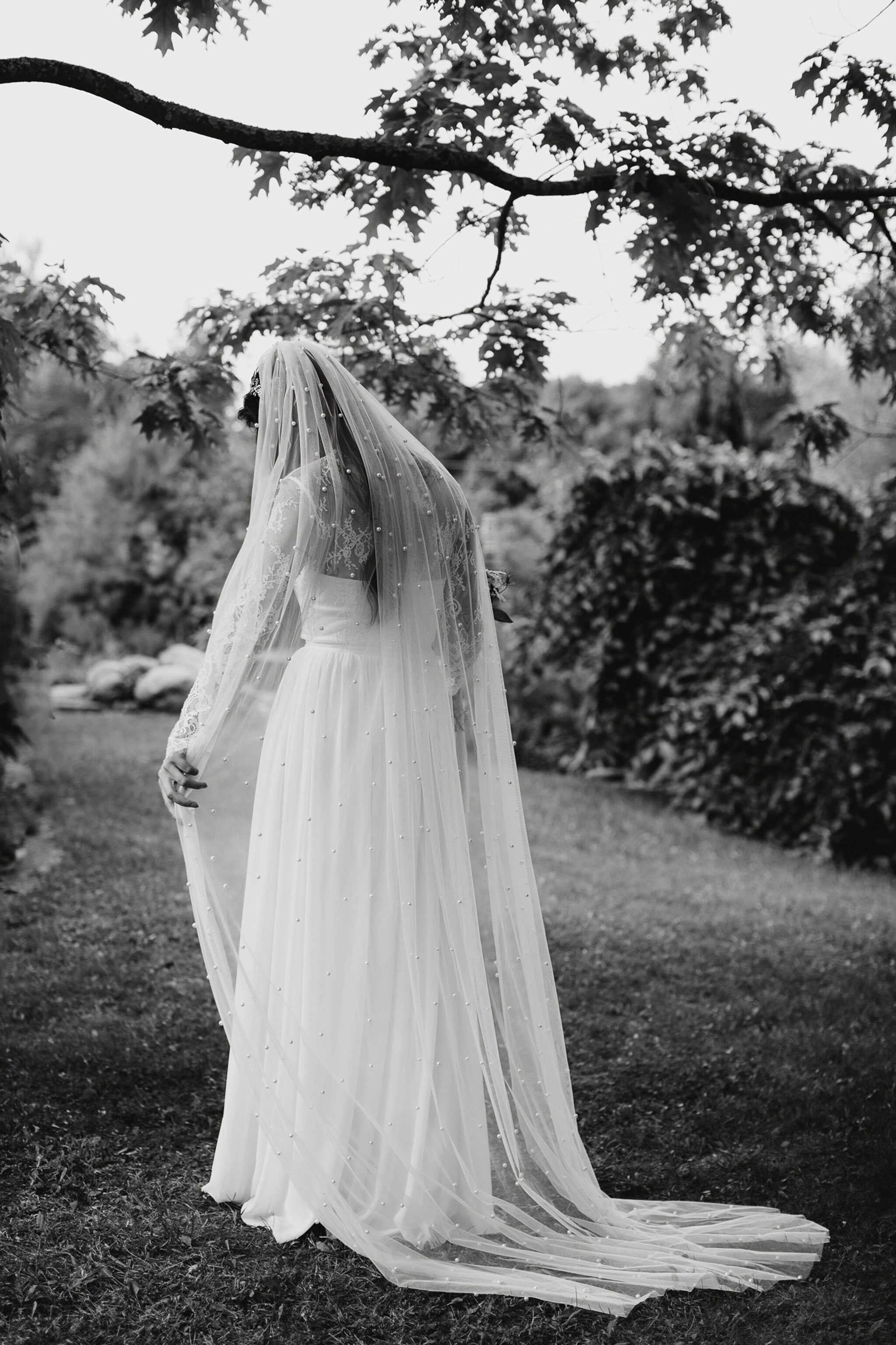 bride stands under dress with cathedral veil with detailing