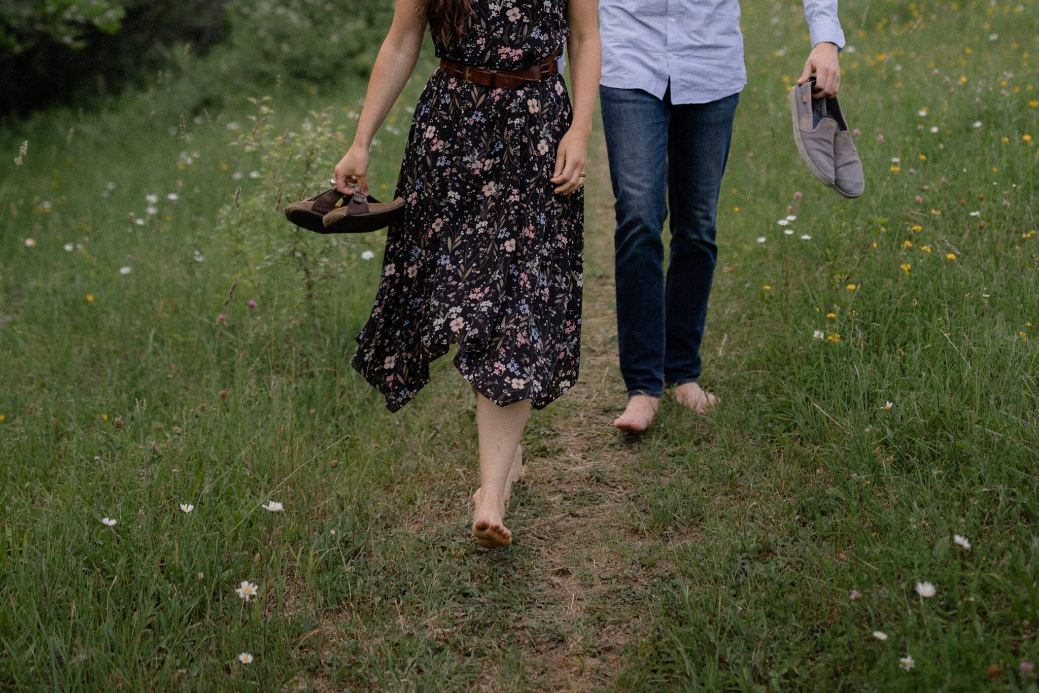 couple walk barefoot during wildflower engagement session