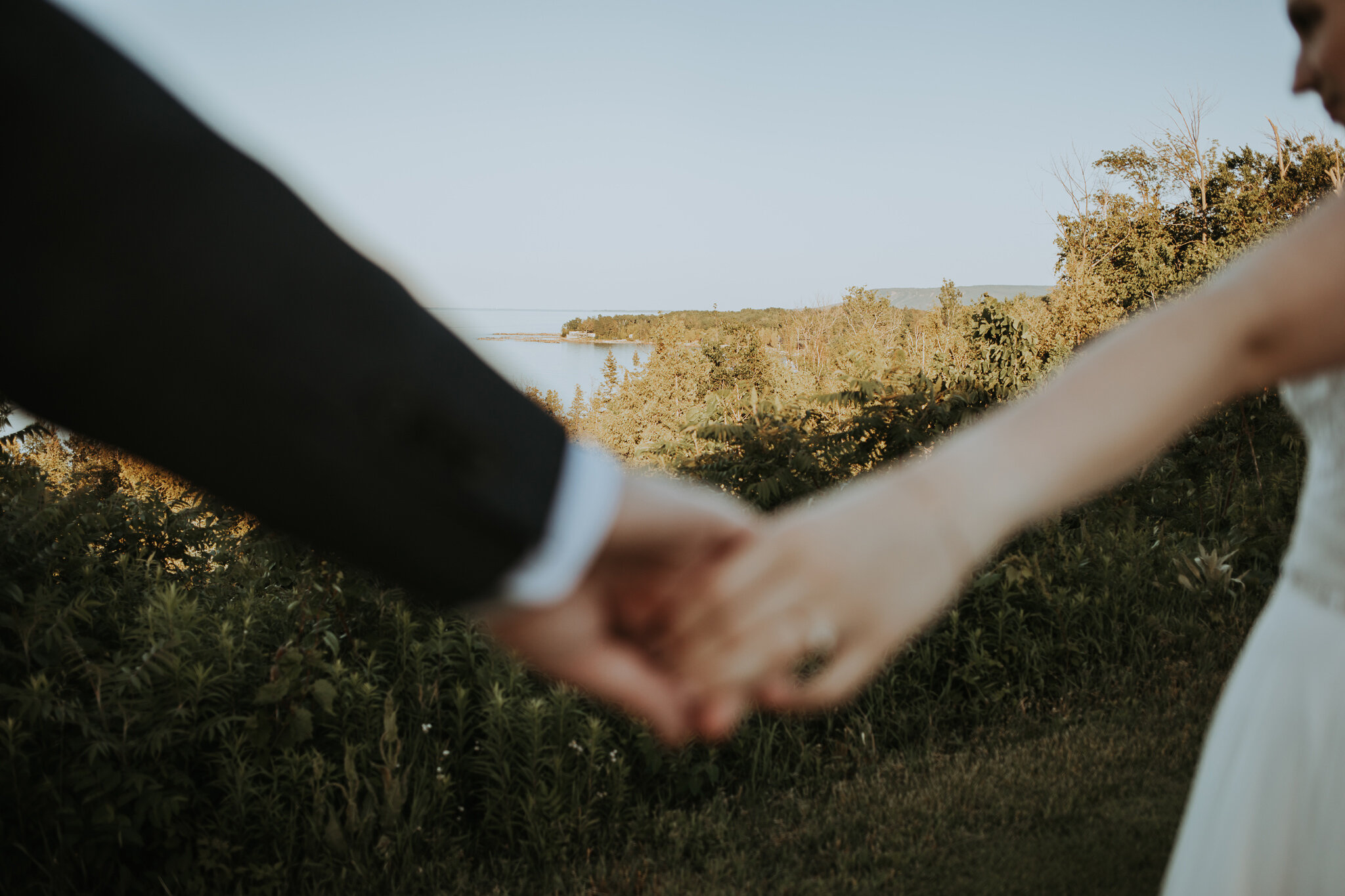 Couple hold hands with Niagara Escaprment in background