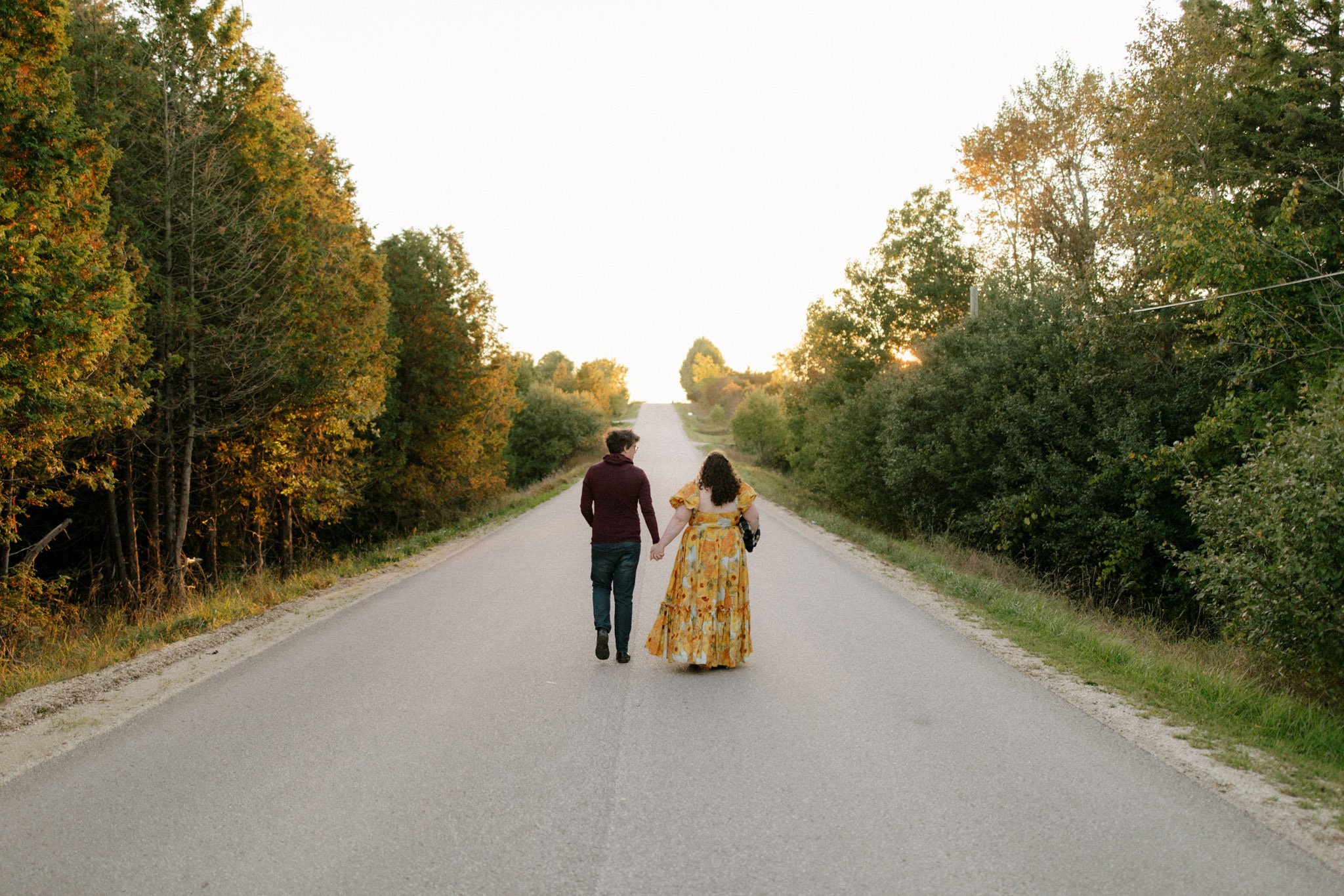 Couple walking down a rural road at sunset in Grey Highlands