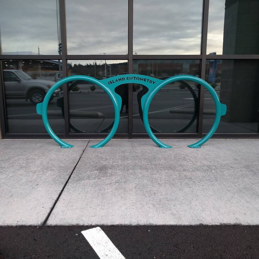 Bike parking is up at @islandoptometry from the desk of @makenorthwest . Love the color contrast against the earth tone storefront! #biketowork
