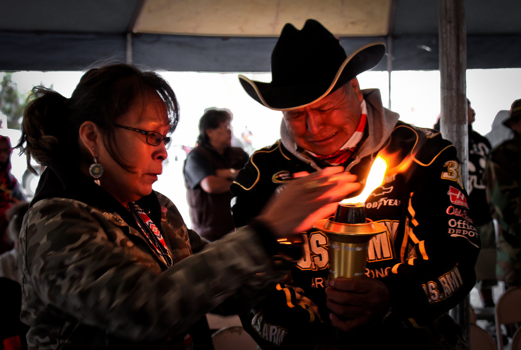 "A Navajo Gold Star family receiving the strength and warmth of the ceremonial torch as they remember their lost one during the 9th annual Navajo-Hopi Honor Run’s torch ceremony. The ceremonial torch is from “Carry the Flame Across America,” a non-profit organization that is dedicated to the honor and memory of Veterans." Photo: Donovan Shortey . See more of his work curated at Navahophotography.org