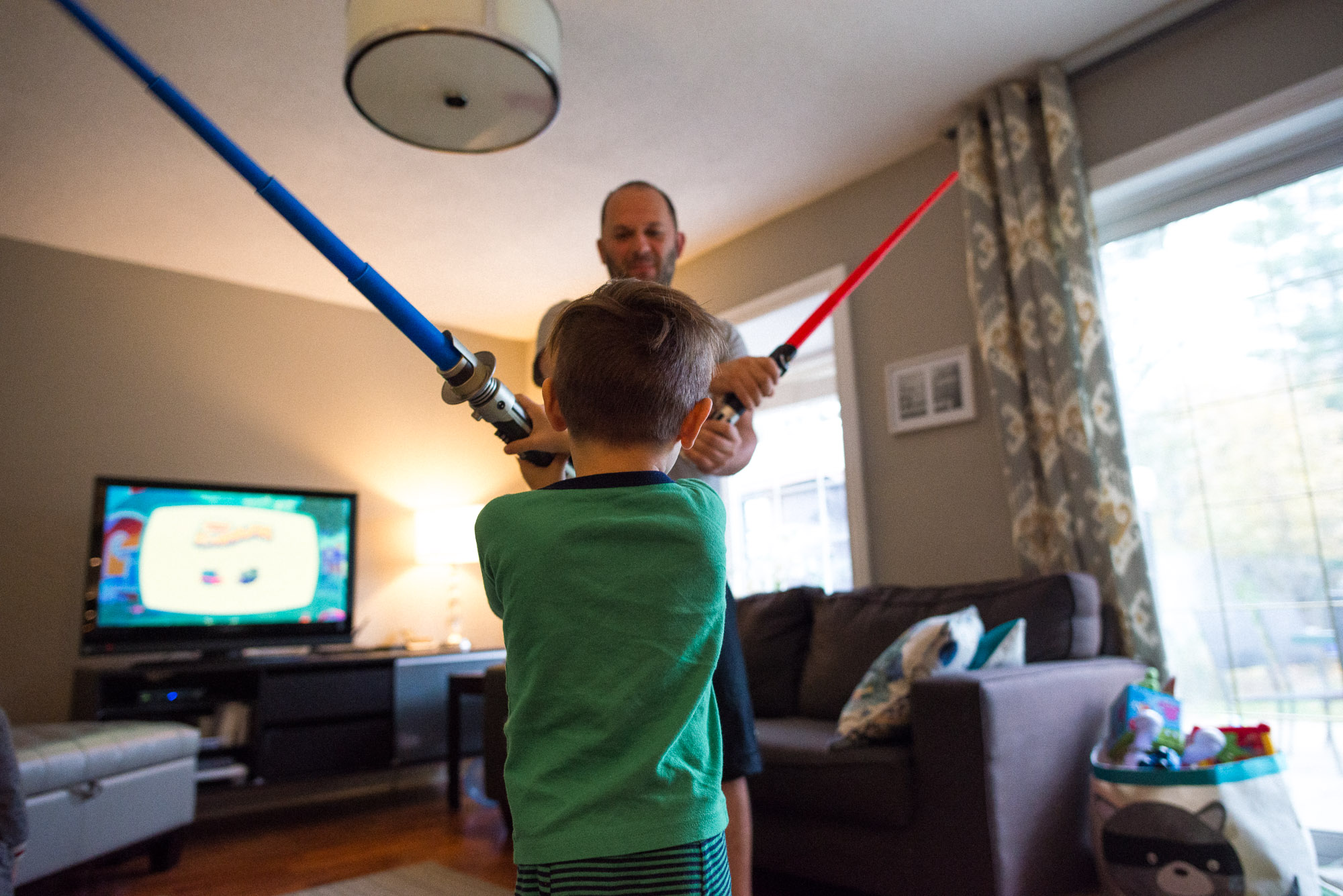 father and son play with light sabers