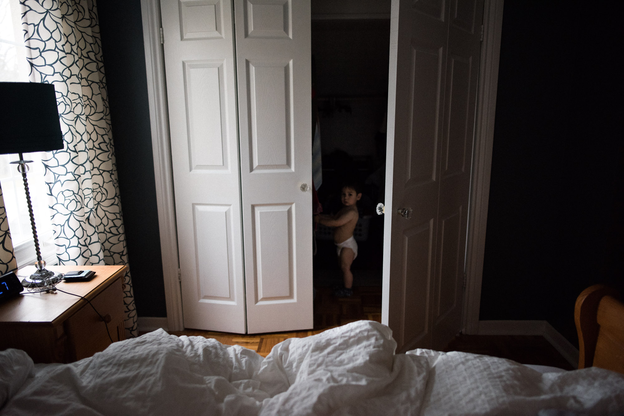 toddler with a diaper hides in a closet