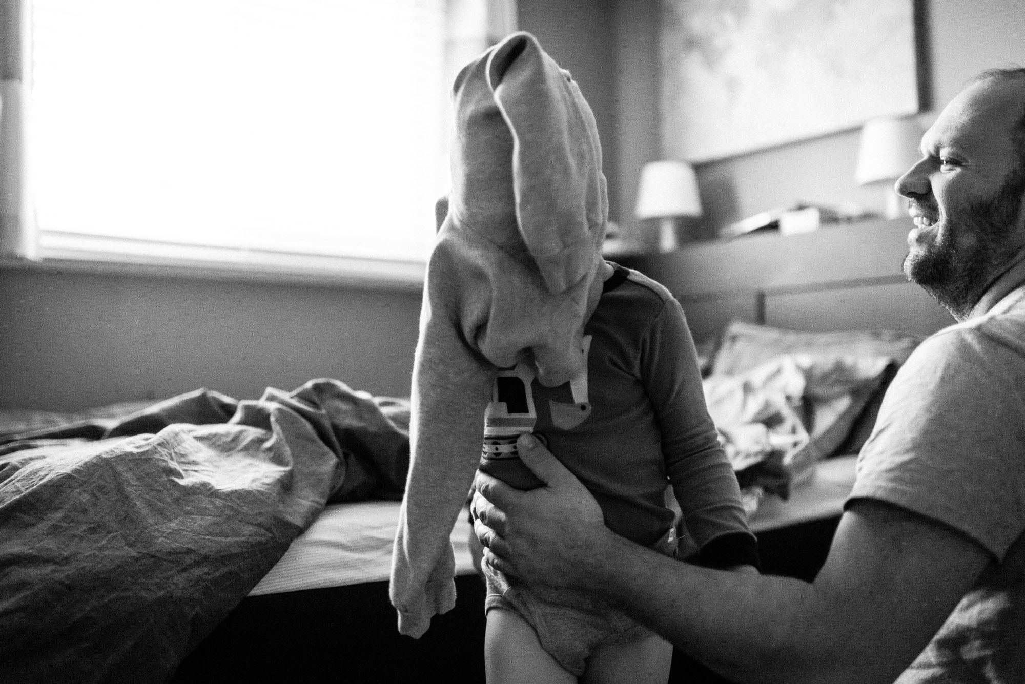 dad smiles at boy with pants on his head