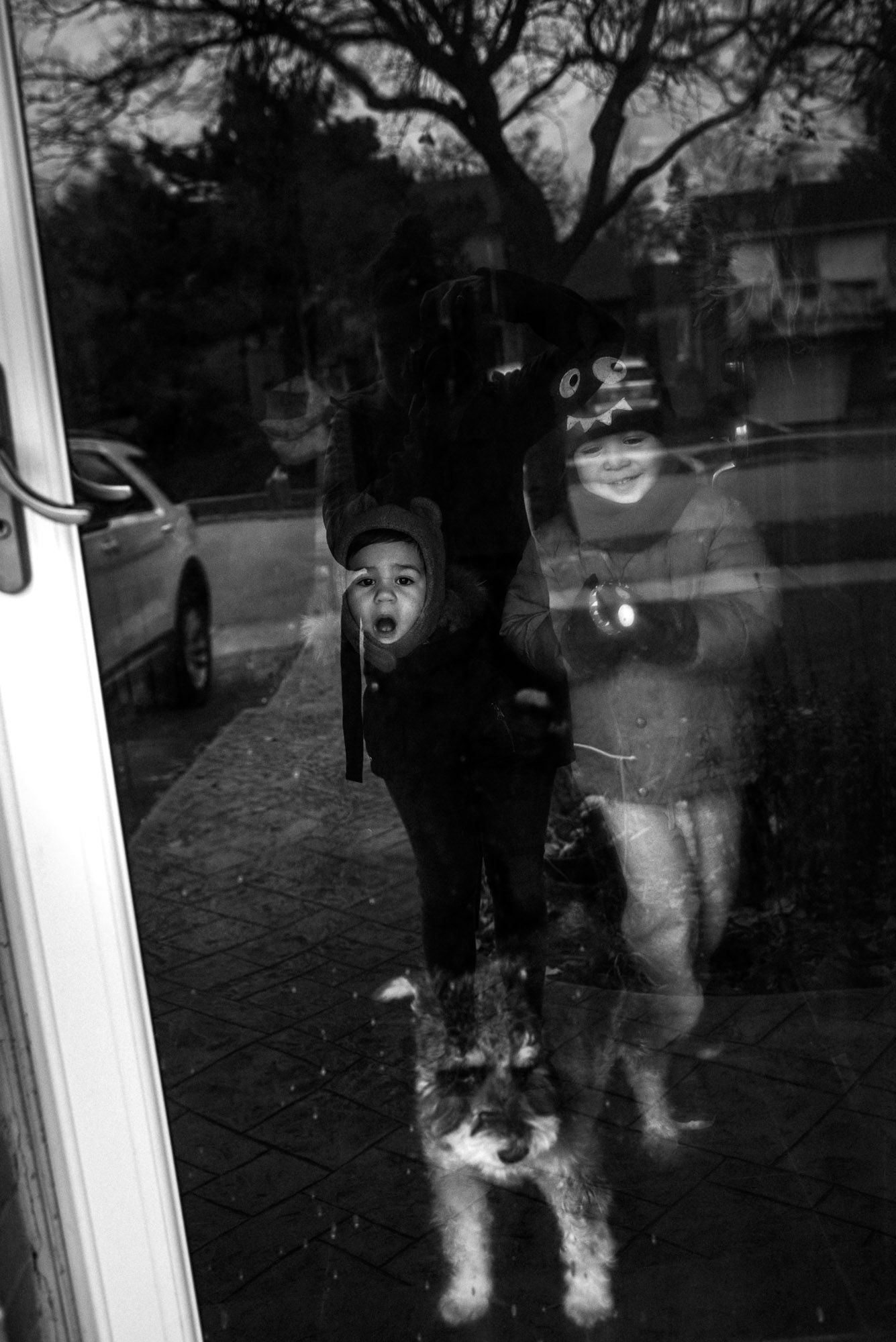 children's faces in black and white through the outside door