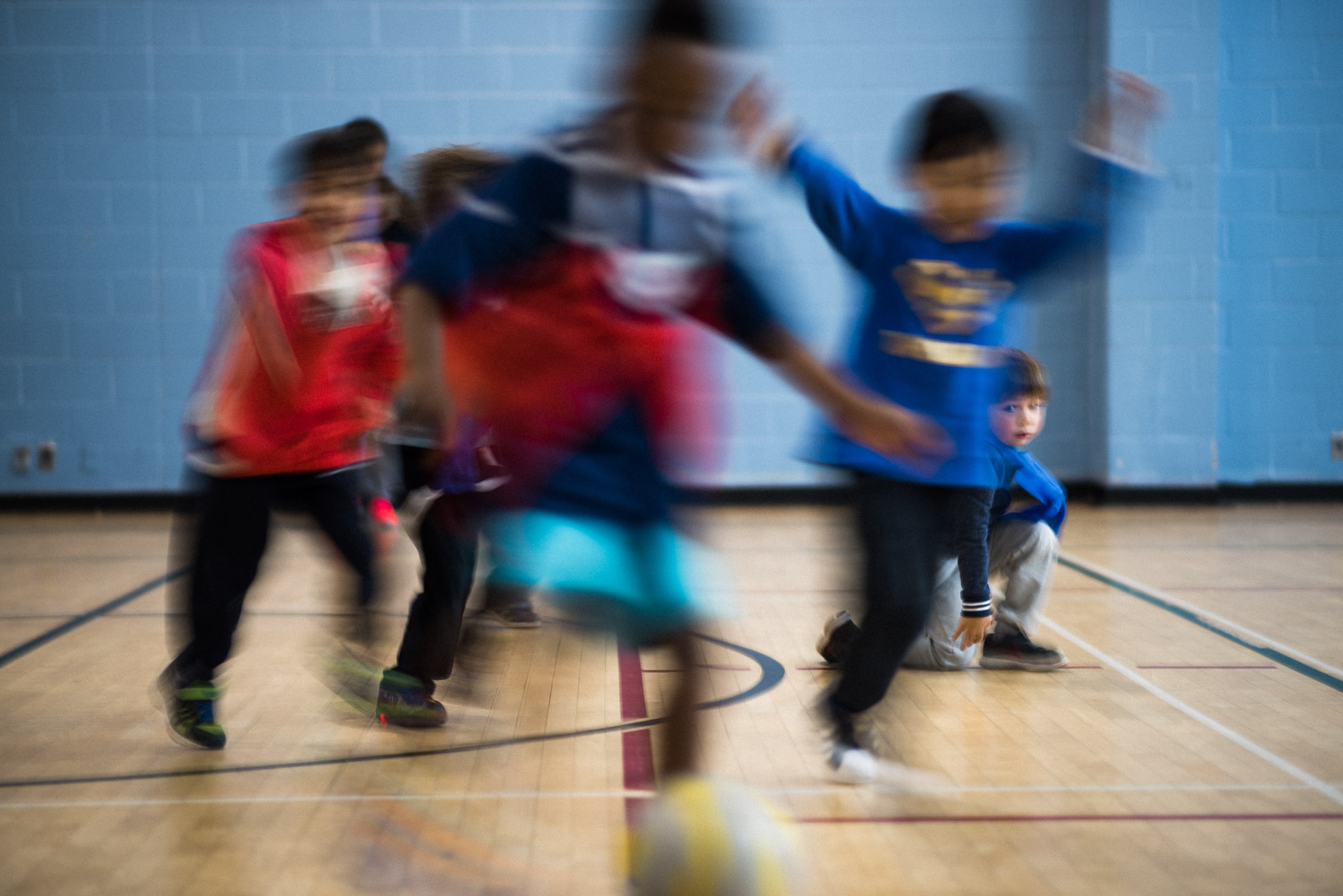 blur of children playing soccer with blue tones