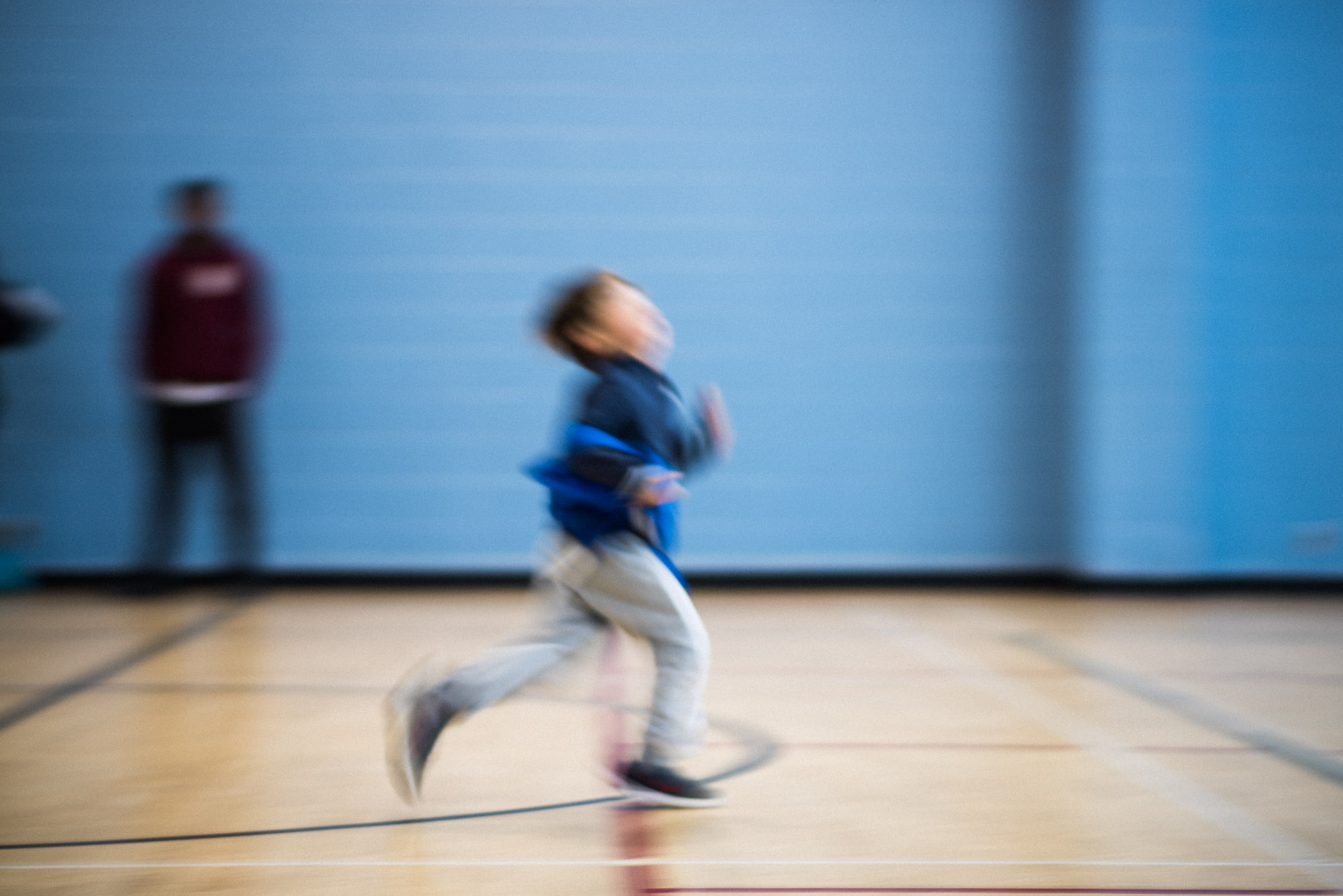 motion blur boy runs at soccer practice dressed in blue bib