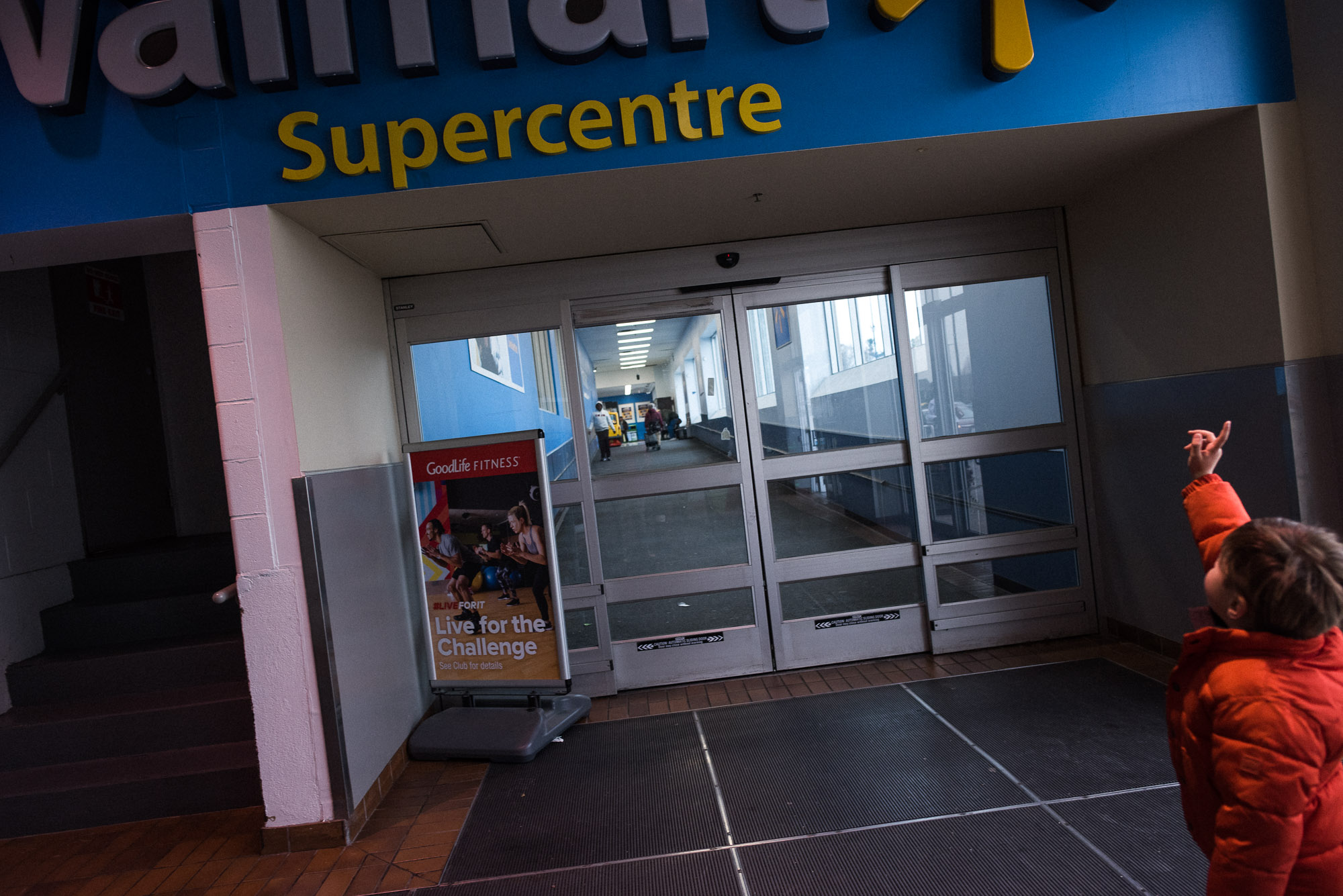 boy points up to a walmart sign