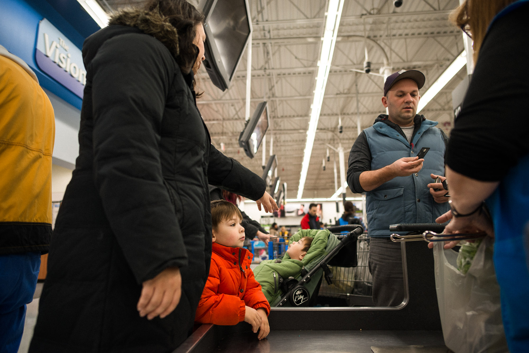 family stands at checkout counter