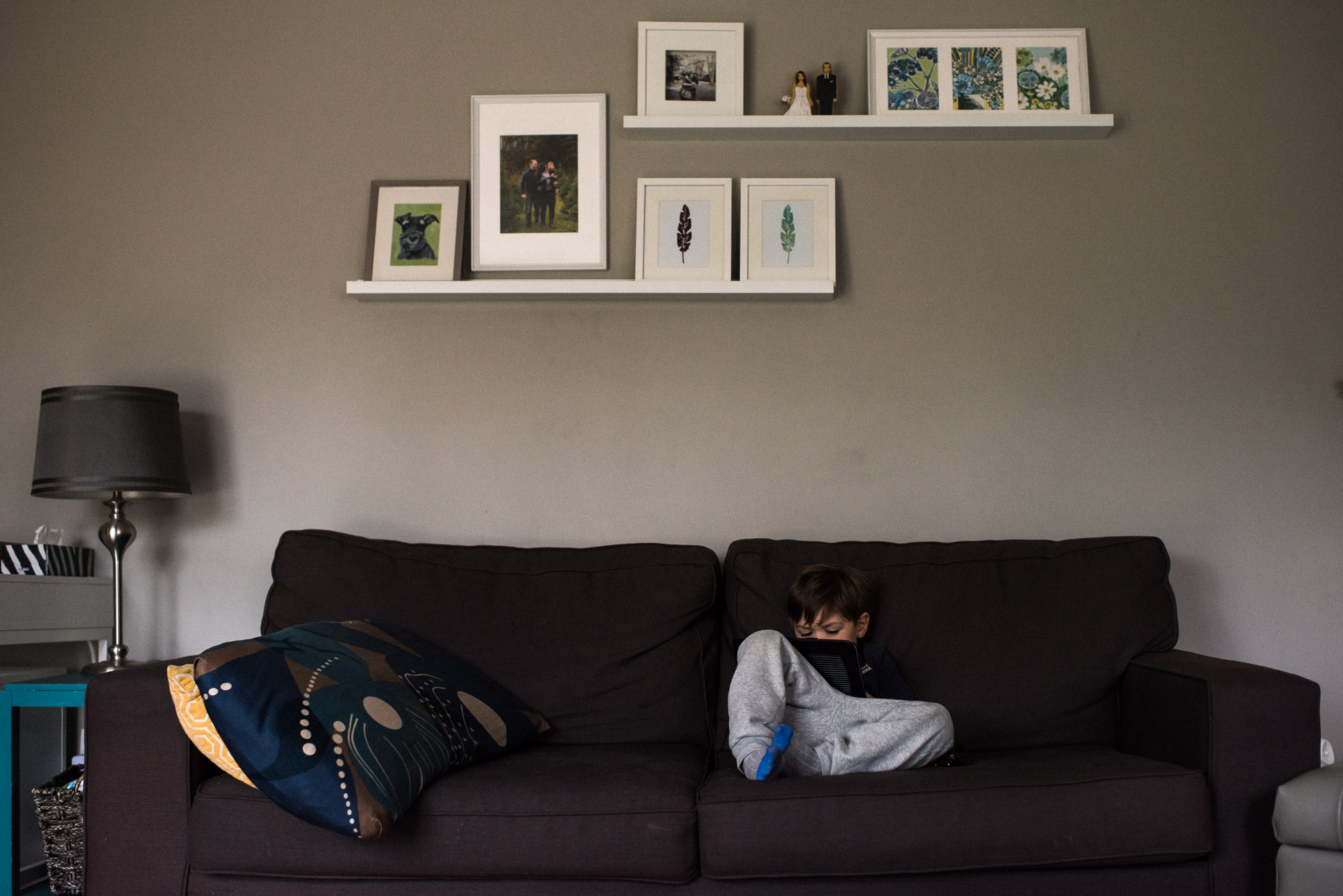 boy plays on his ipad o the couch
