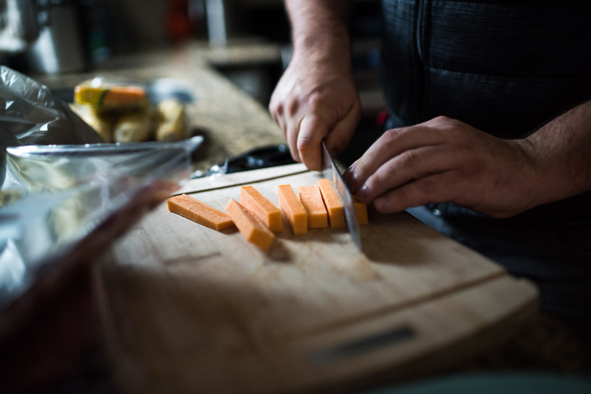 male hands cutting cheese in natural light