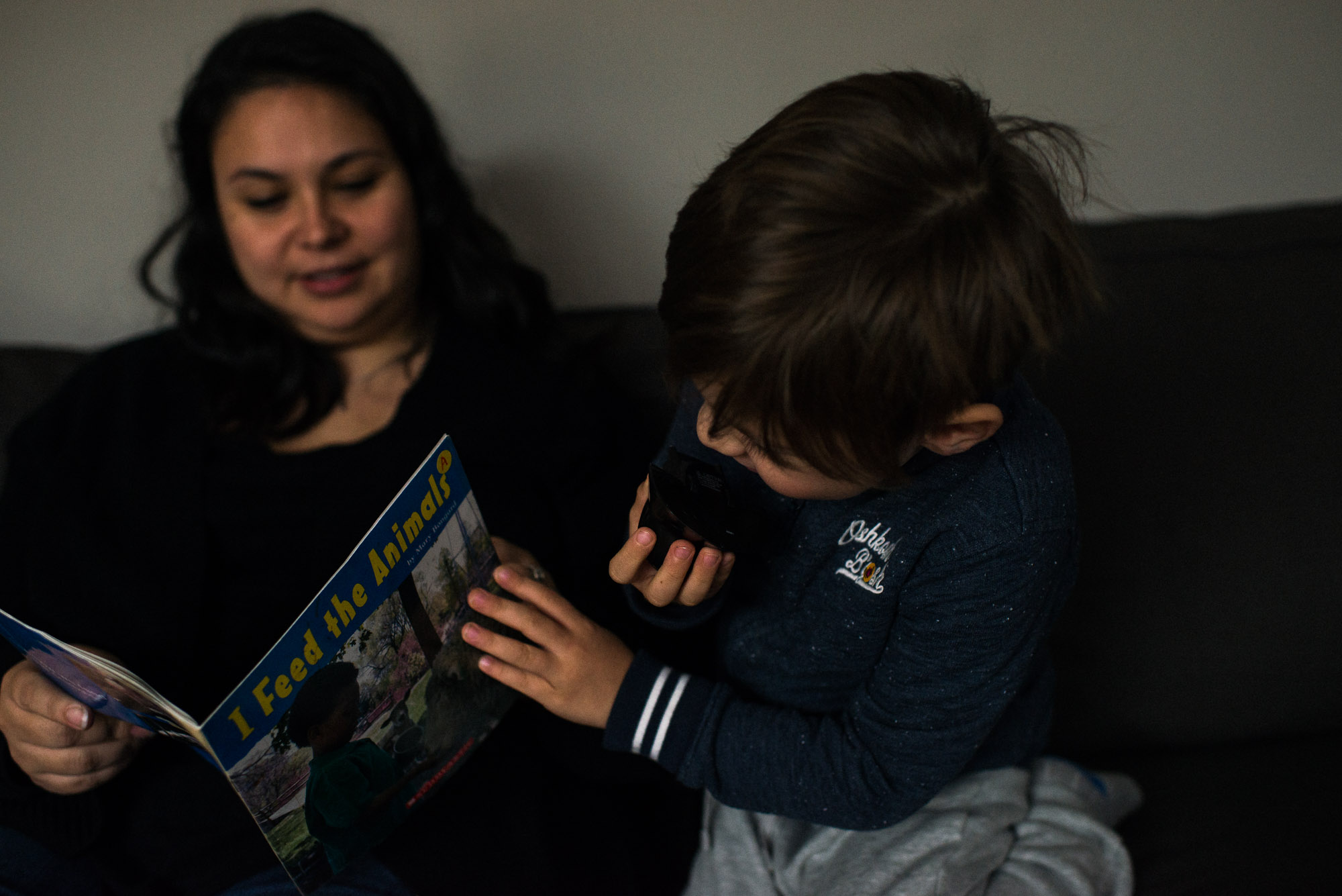 boy checks front page of book mom reads to him