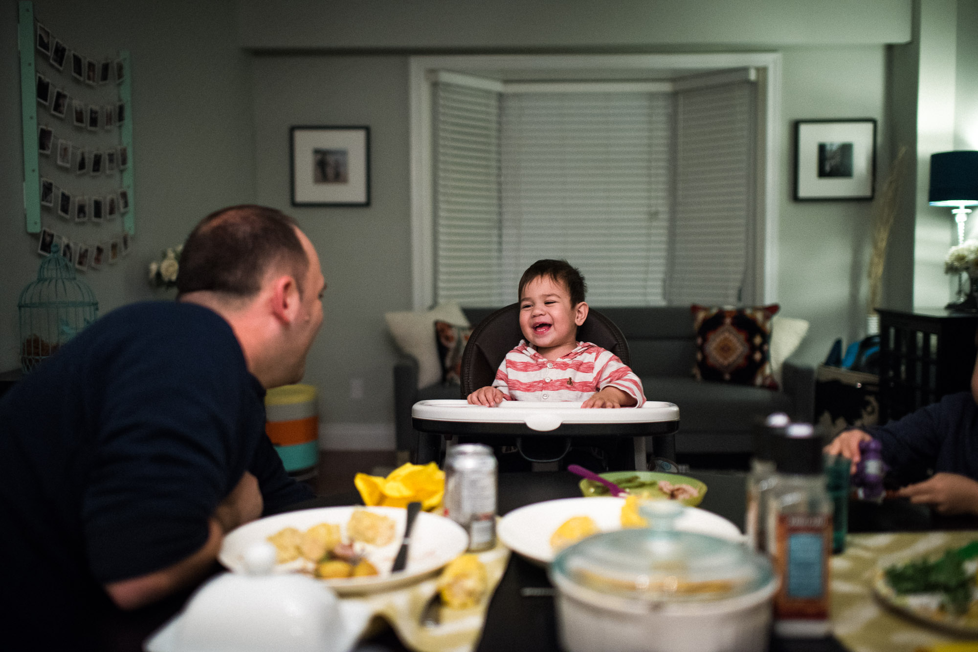 dad and toddler exchange smiles at dinnertable