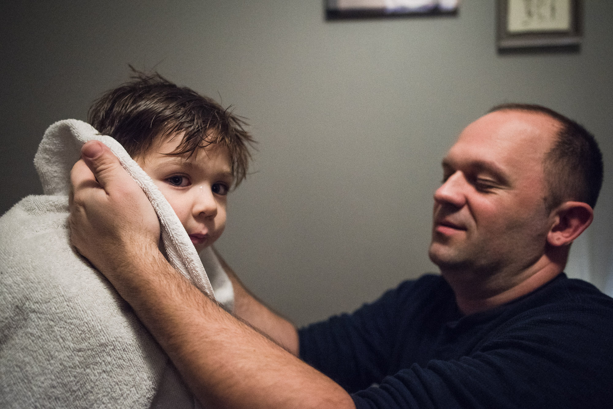 dad dries off boy's ears with a towel