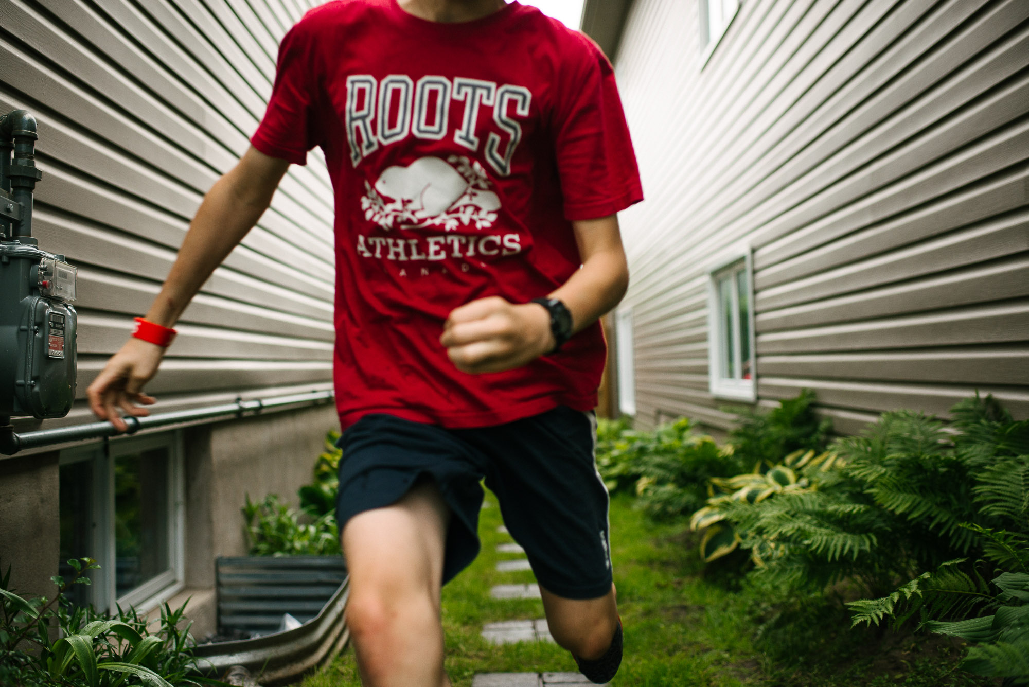 boy with red shirt runs toward camera