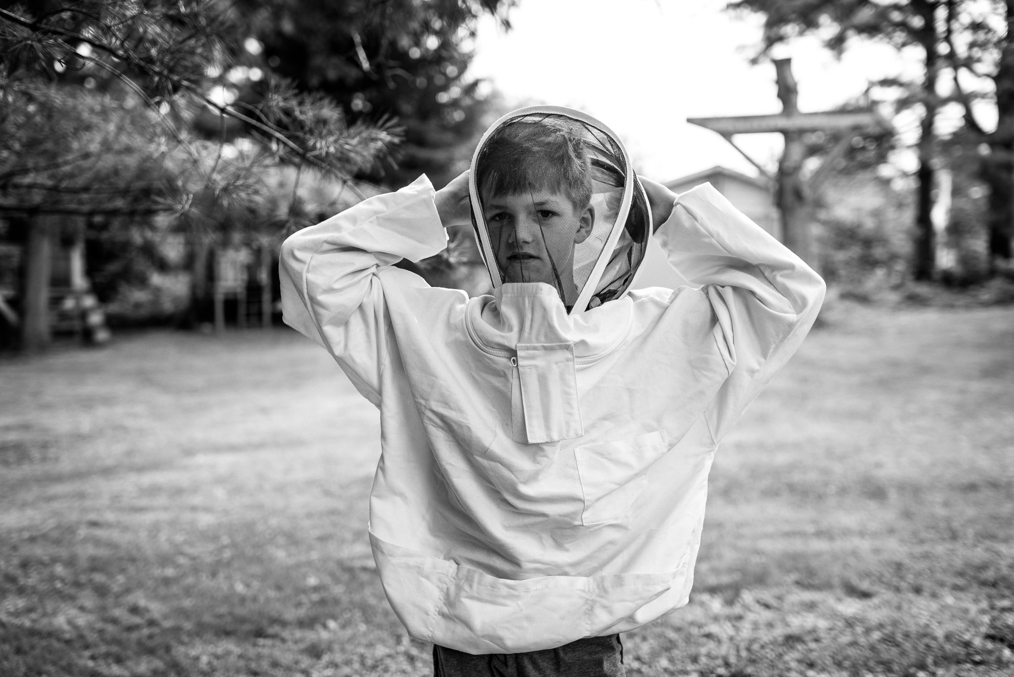 boy wears a beekeeping outfit