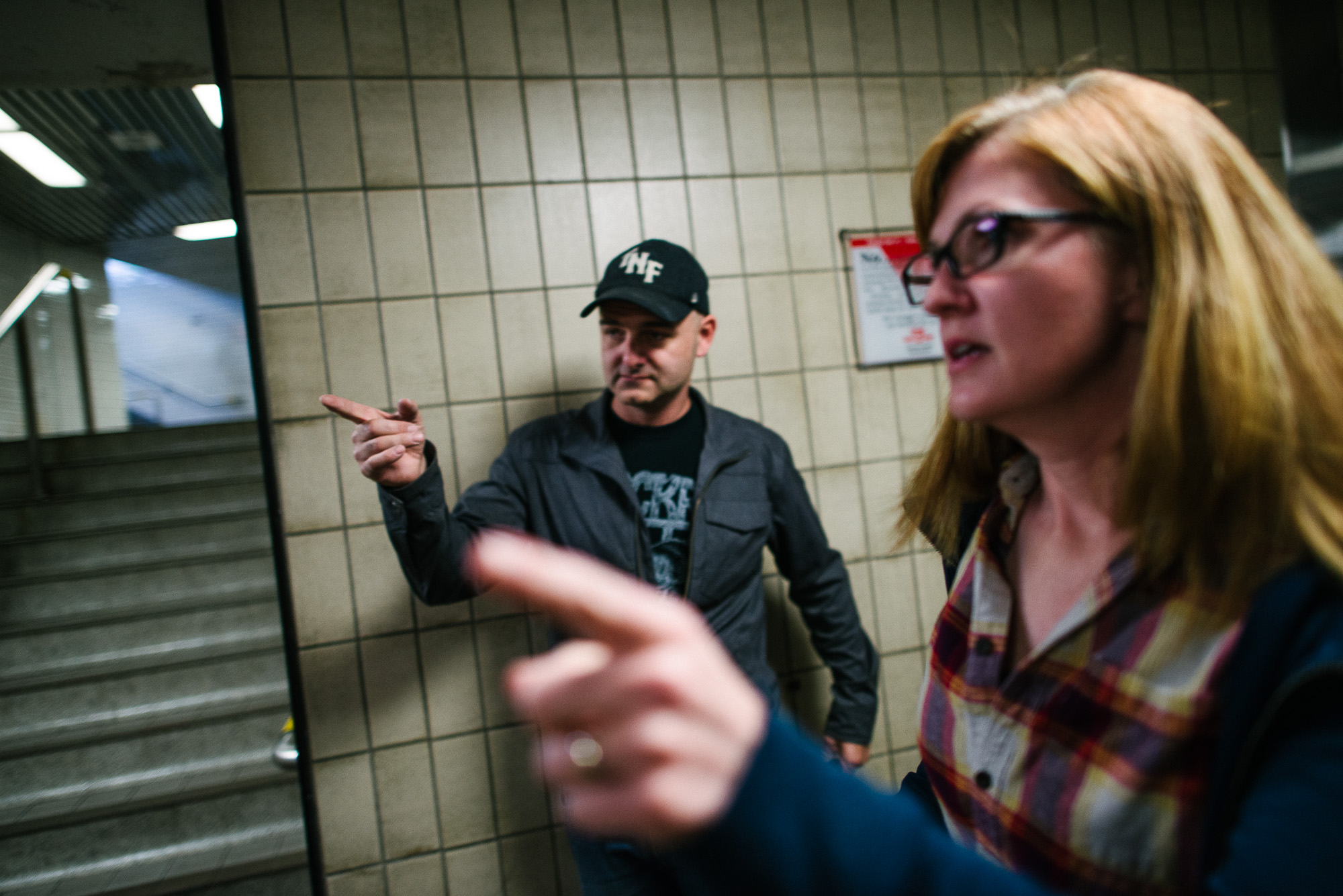 man and woman point in a subway tunnel