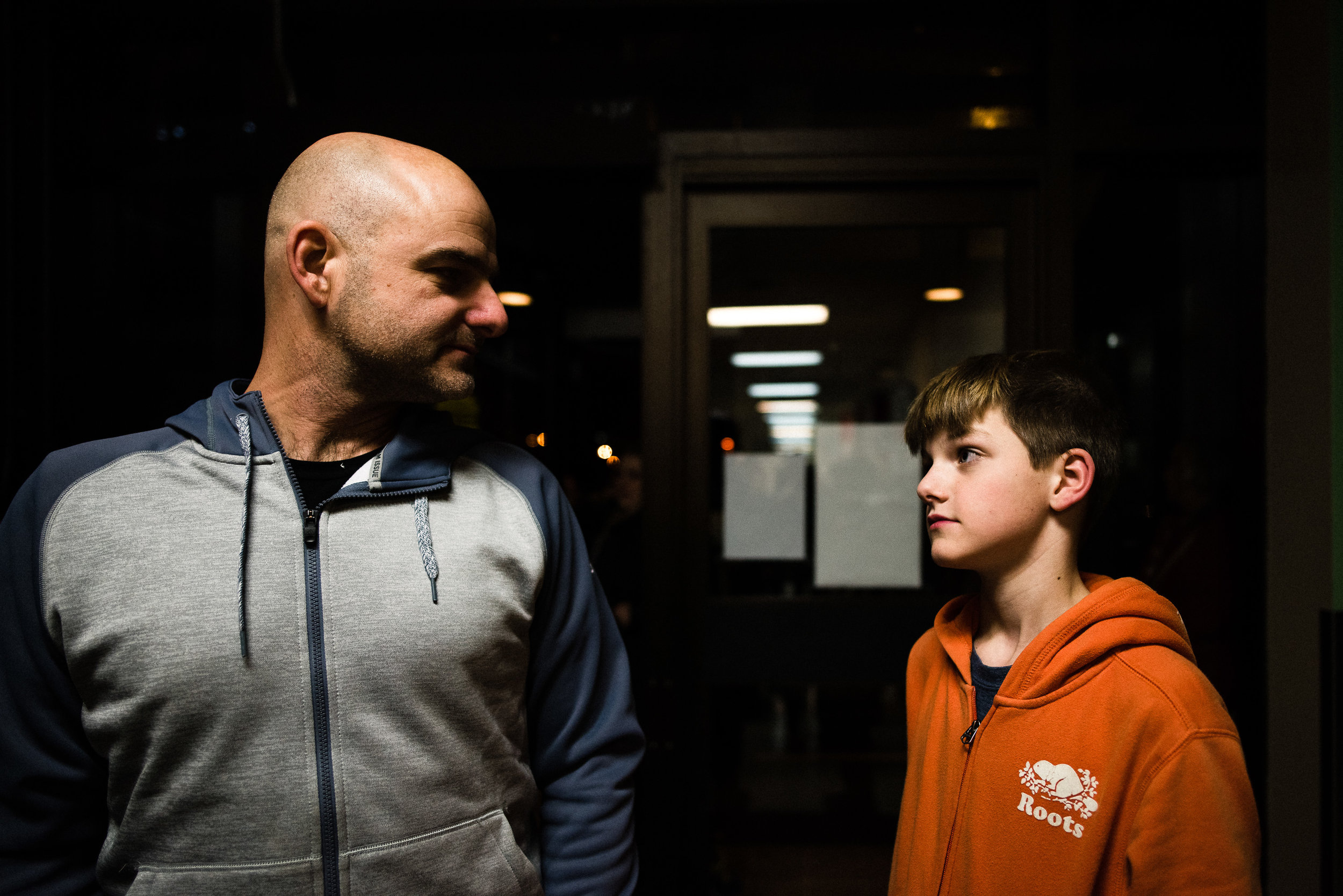 father and son look at each other under indoor lights