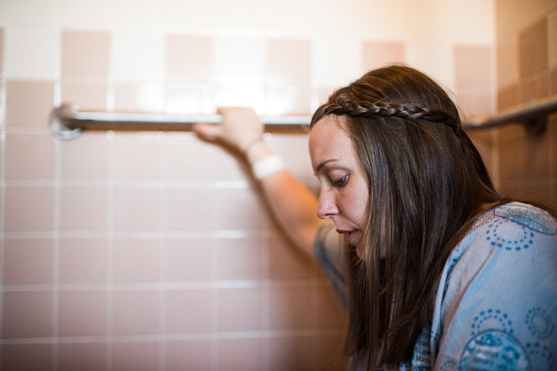 labouring mother holds shower handrail during a contraction