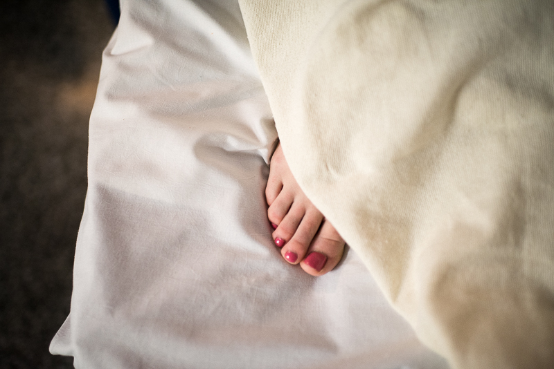 mother's toes peek out of the blanket after giving birth