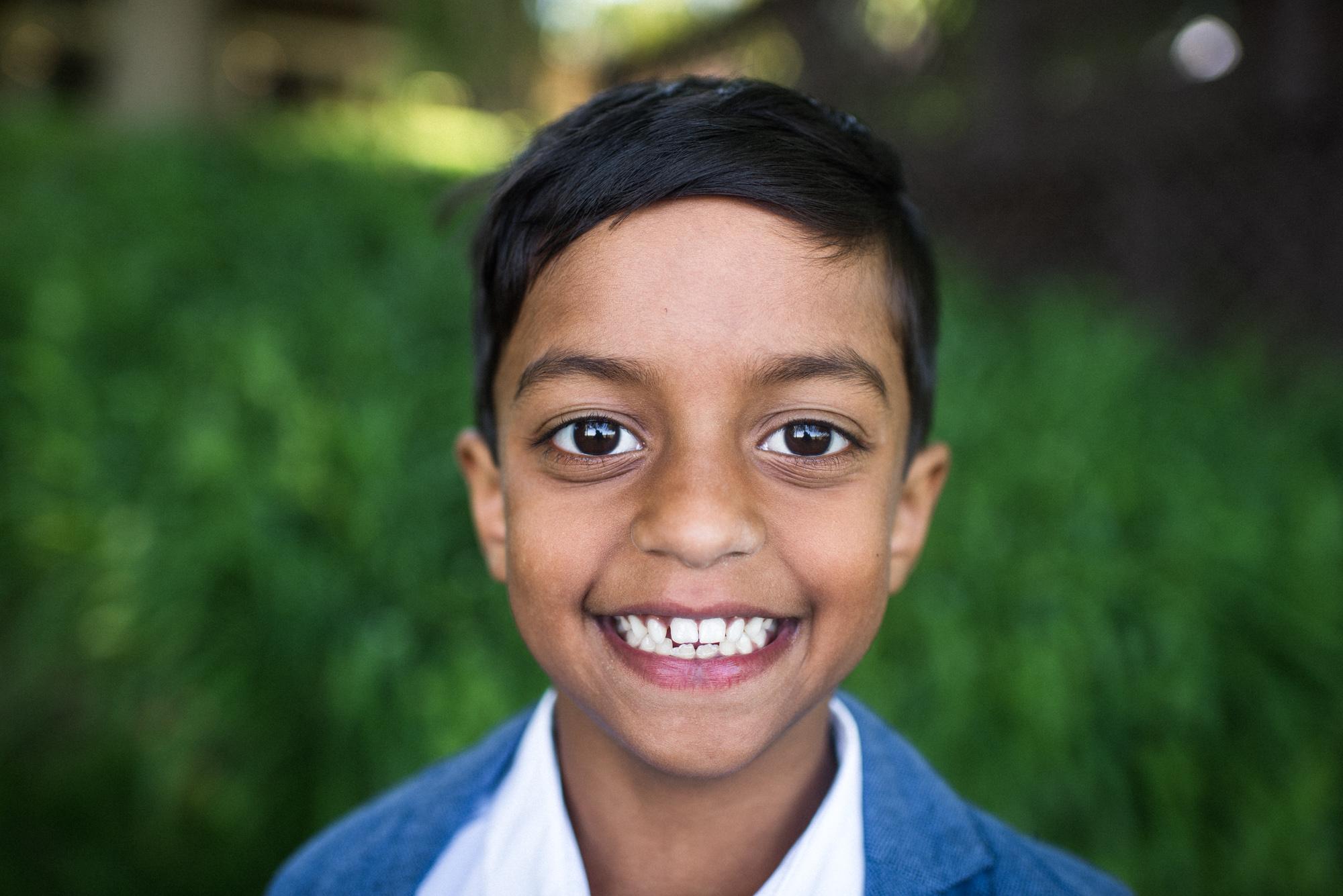boy in a blue suit smiles at the camera