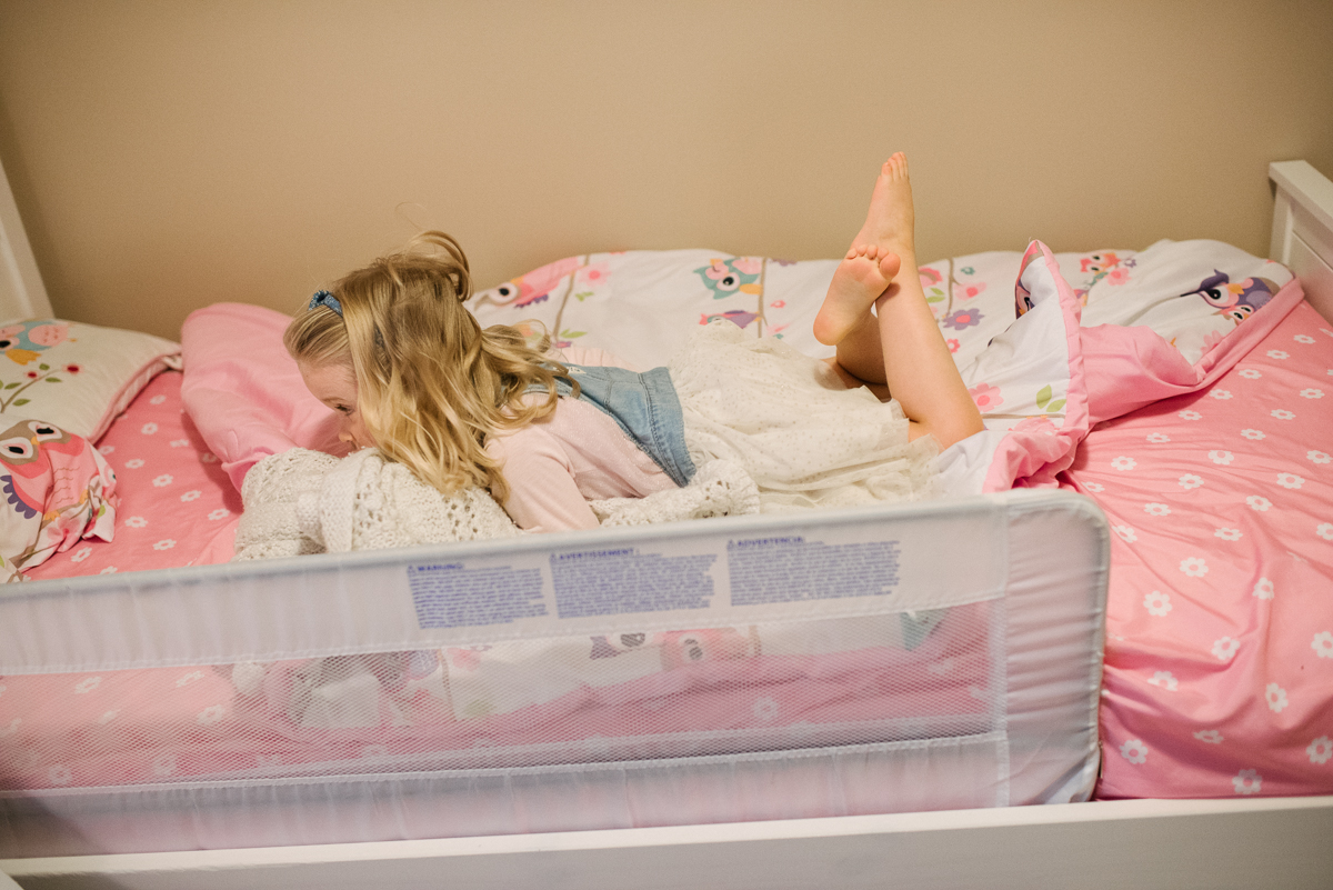 Young girl sleeping on her bed with pink blanket