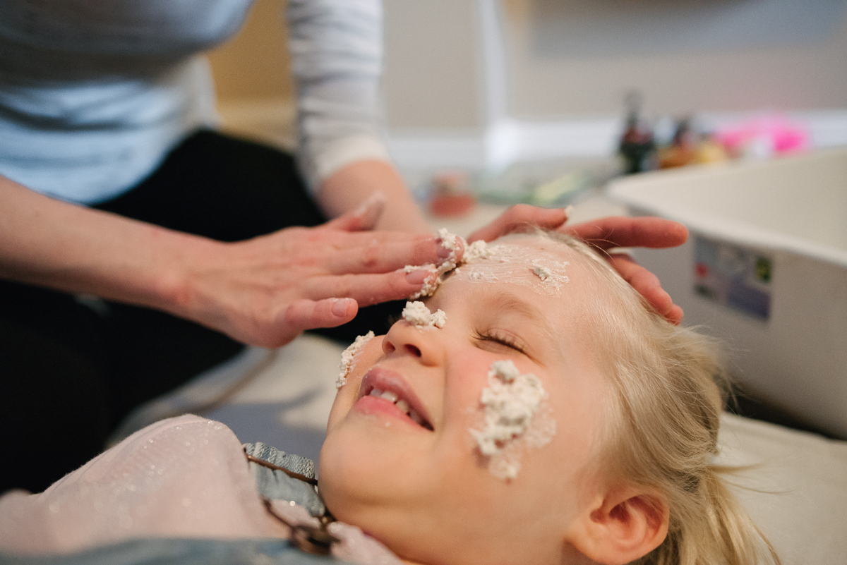 Daughter getting face treatement from mother