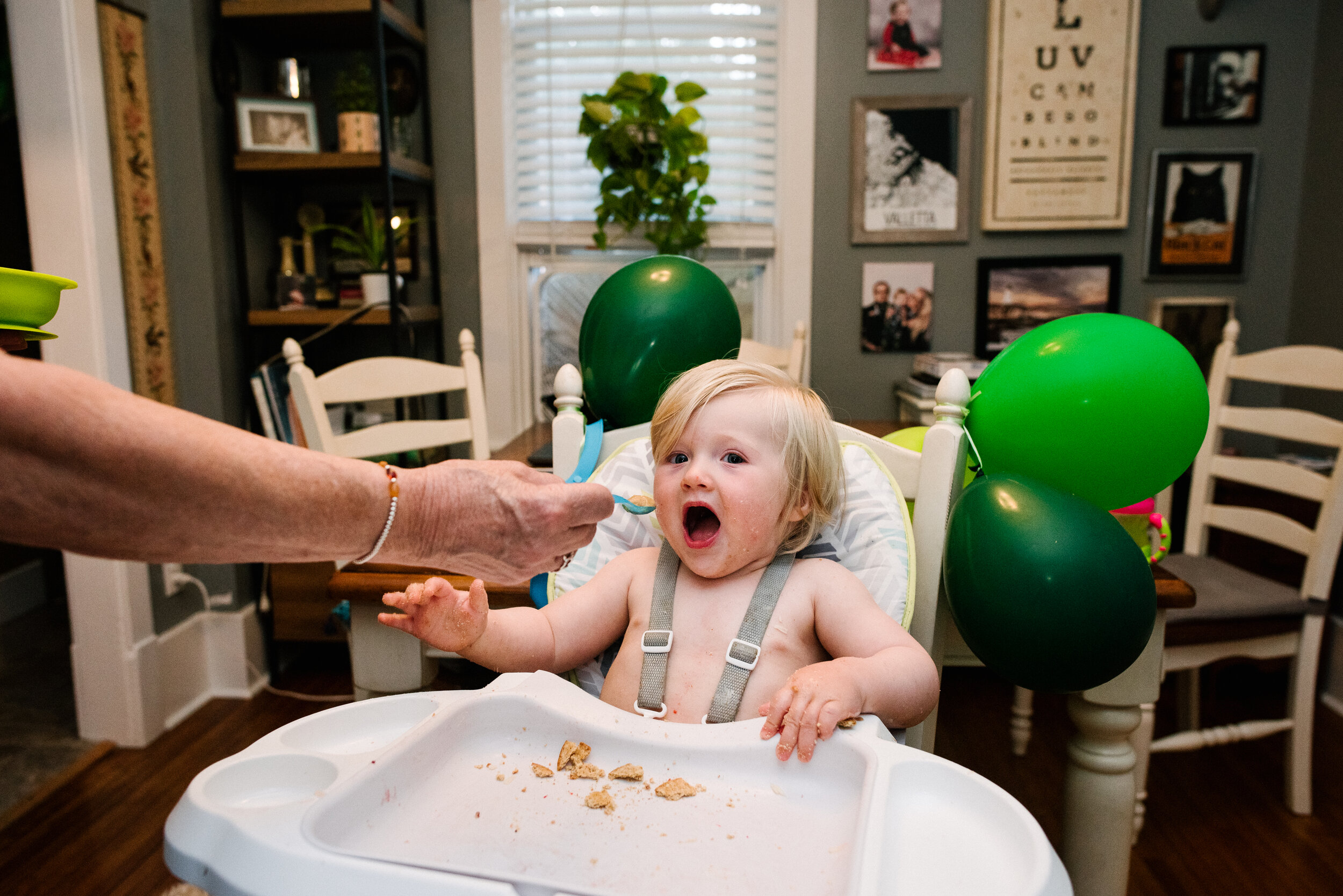 Toddler eating at his high chair during a family photo session in Kingston, Ontario