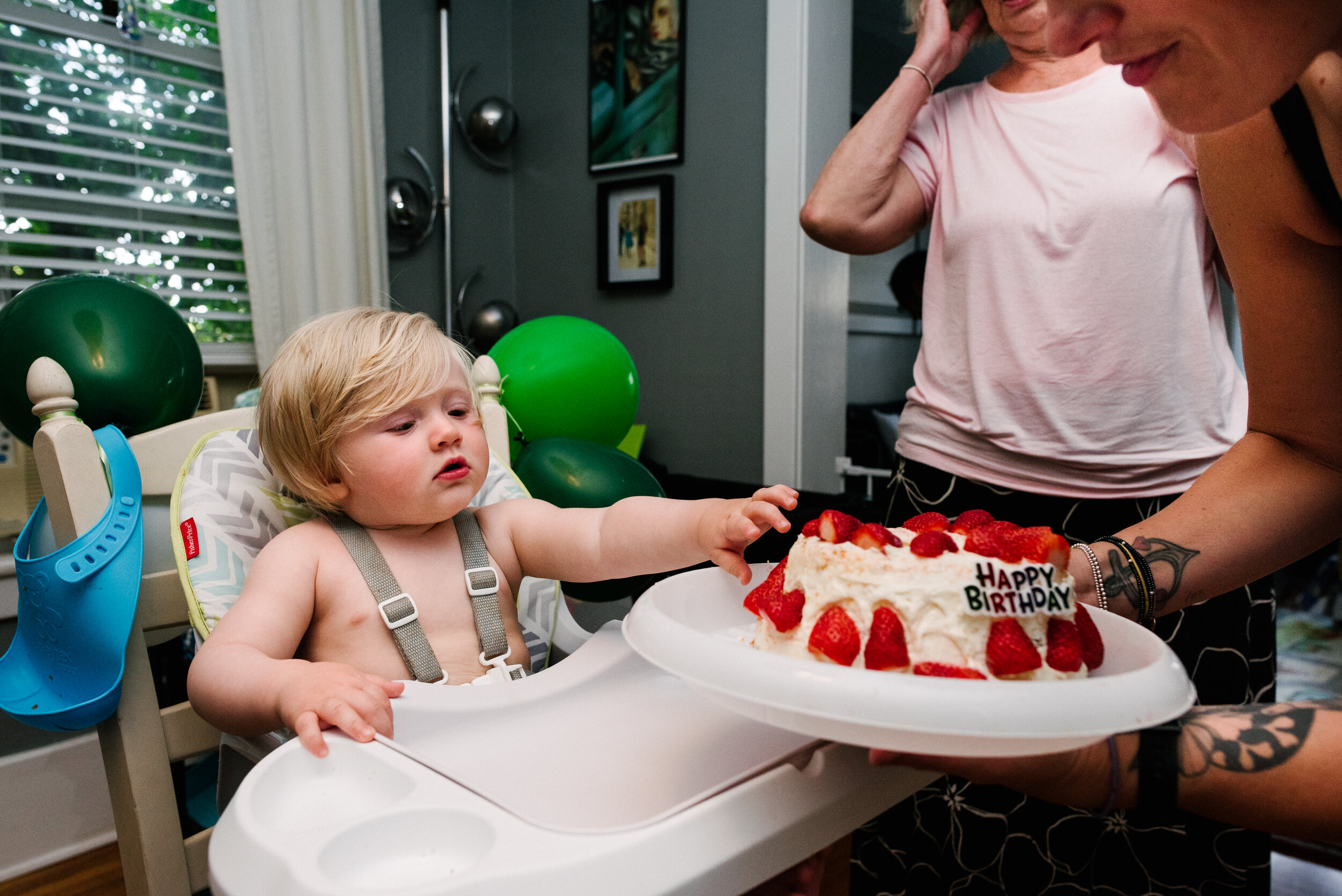 Toddler being shown his birthday cake on his first birthday during a family photo session in Kingston, Ontario
