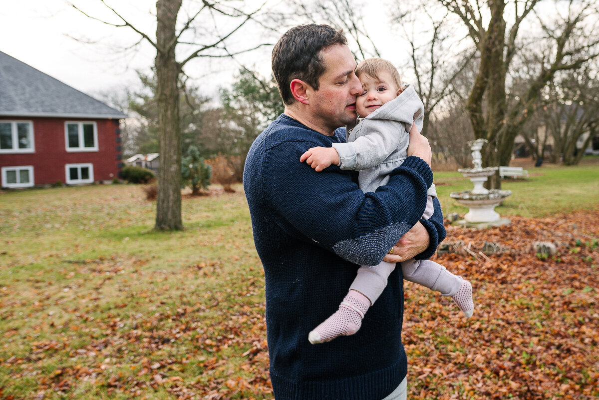 father holding baby outside, viara mileva family photojournalism 