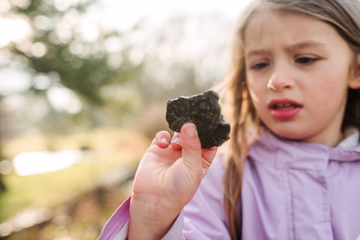 girl finds rock, during day in the life session playing outside