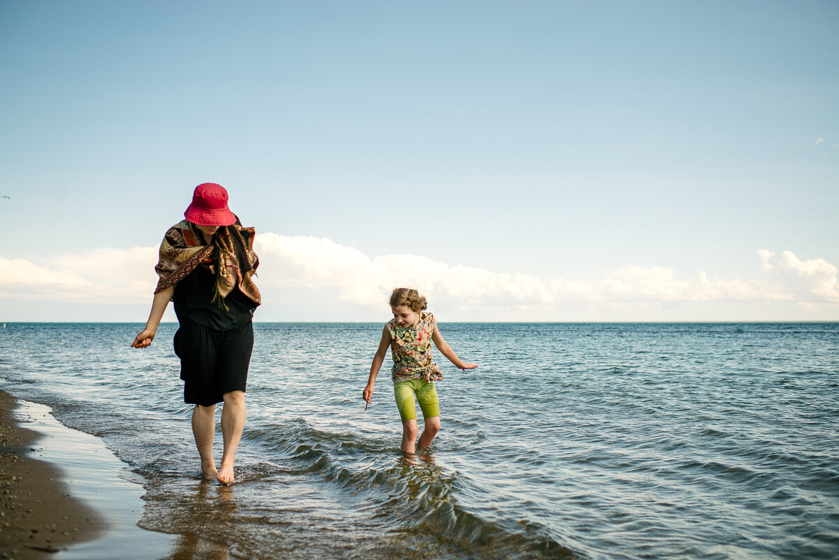 Mother and daughter walking in the water at the beach, during day in the life session 