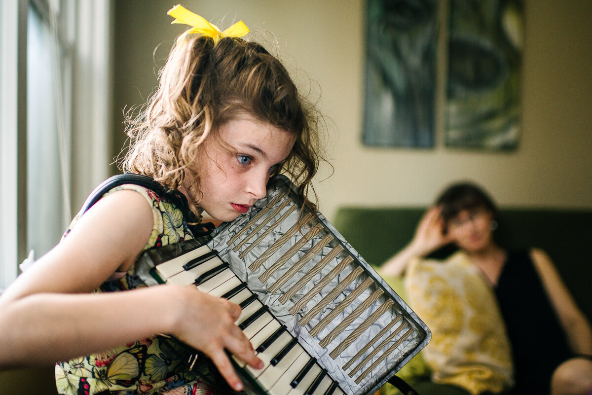 Girl playing accordion at home after a big day in Toronto  