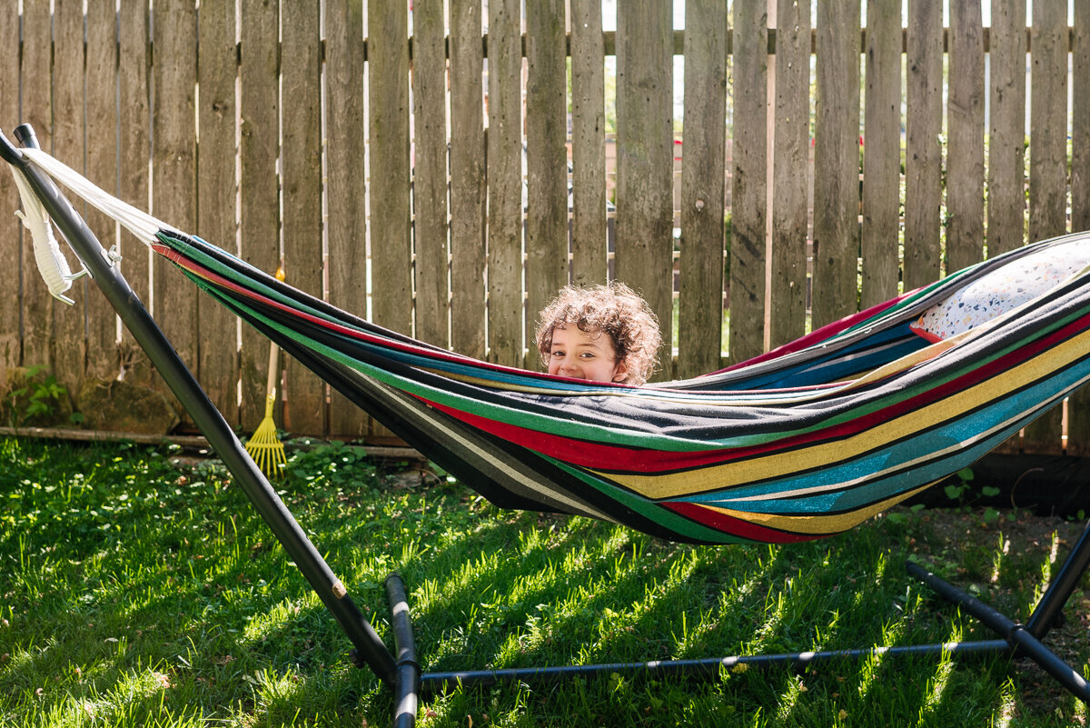 little boy playing in a hammock during candid family photo session 