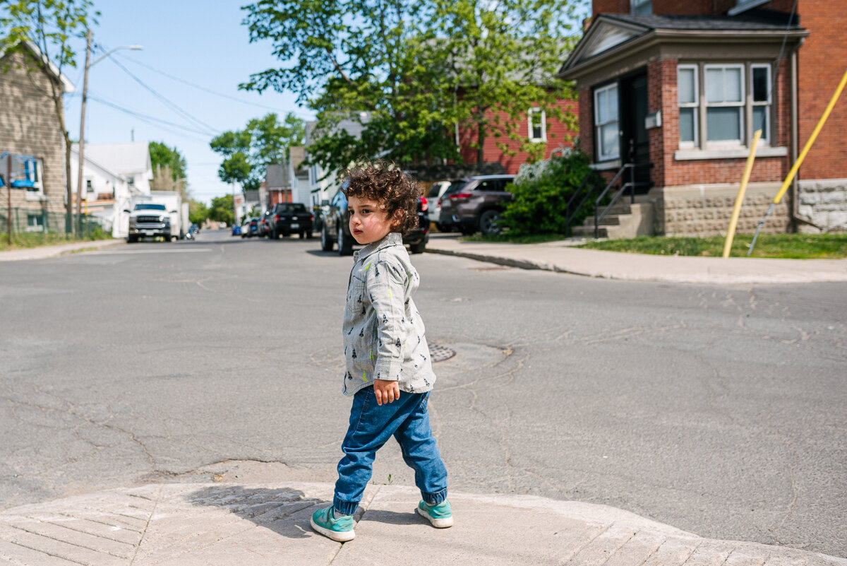 Child standing on the end of the sidewalk 