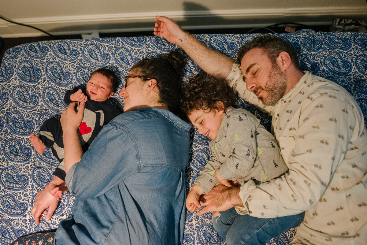 Family sleeping together with happiness on their faces