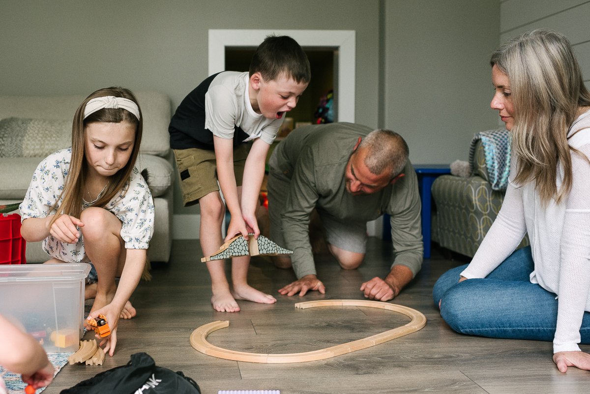 Photo of parents and their kids playing at their home during family photography